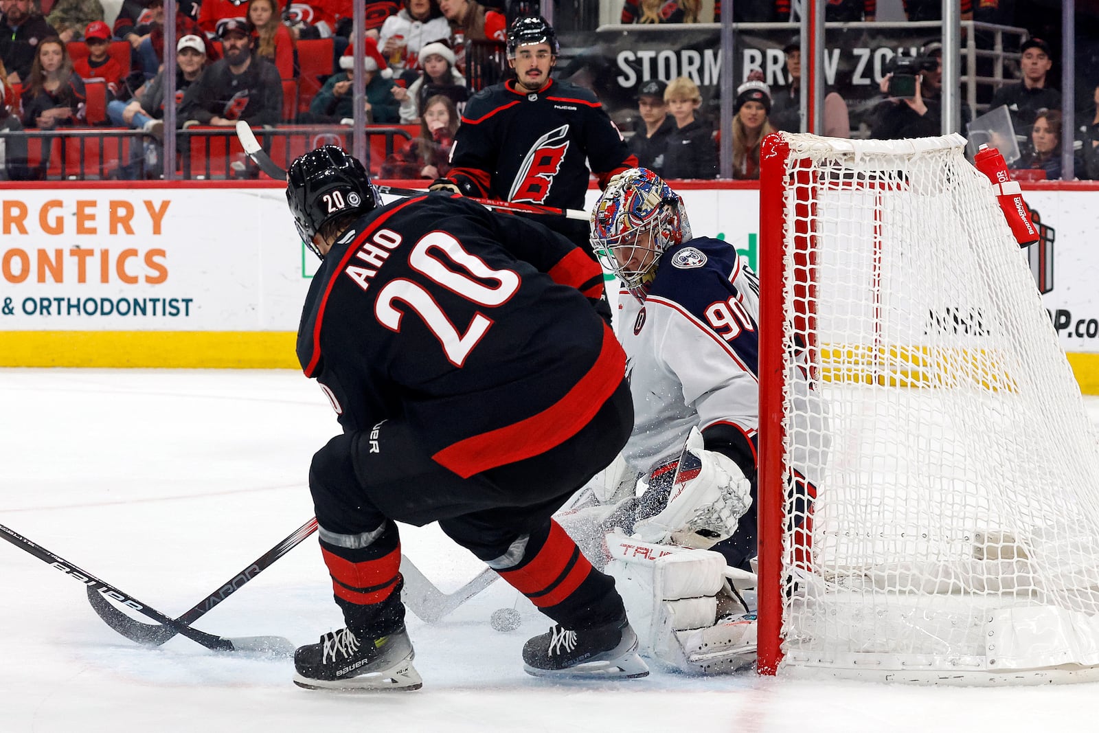 Columbus Blue Jackets goaltender Elvis Merzlikins (90) blocks a shot from Carolina Hurricanes' Sebastian Aho (20) during the second period of an NHL hockey game in Raleigh, N.C., Sunday, Dec. 15, 2024. (AP Photo/Karl B DeBlaker)