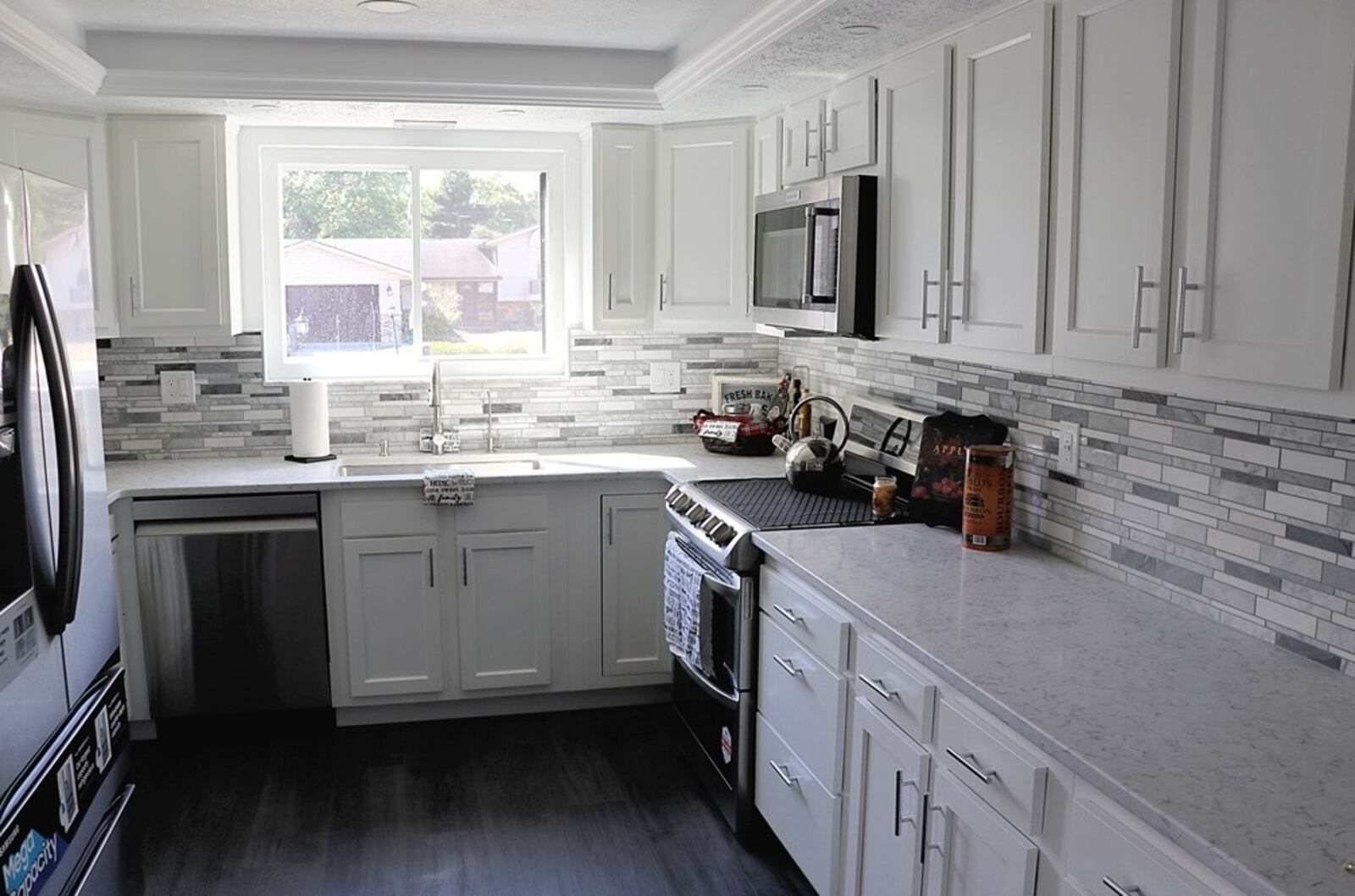 The kitchen in this Princewood Avenue home is tucked off the family room under a tray ceiling at the front of the house. A window is above the sink and white cabinetry with complimenting granite countertops wraps around creating a U-shaped work space. Stainless-steel appliances include a range, microwave, dishwasher and refrigerator. The Ceramic-tile backsplash is in a herringbone design. Access to the garage is off the kitchen as is a short hallway that ends into the dining room. CONTRIBUTED