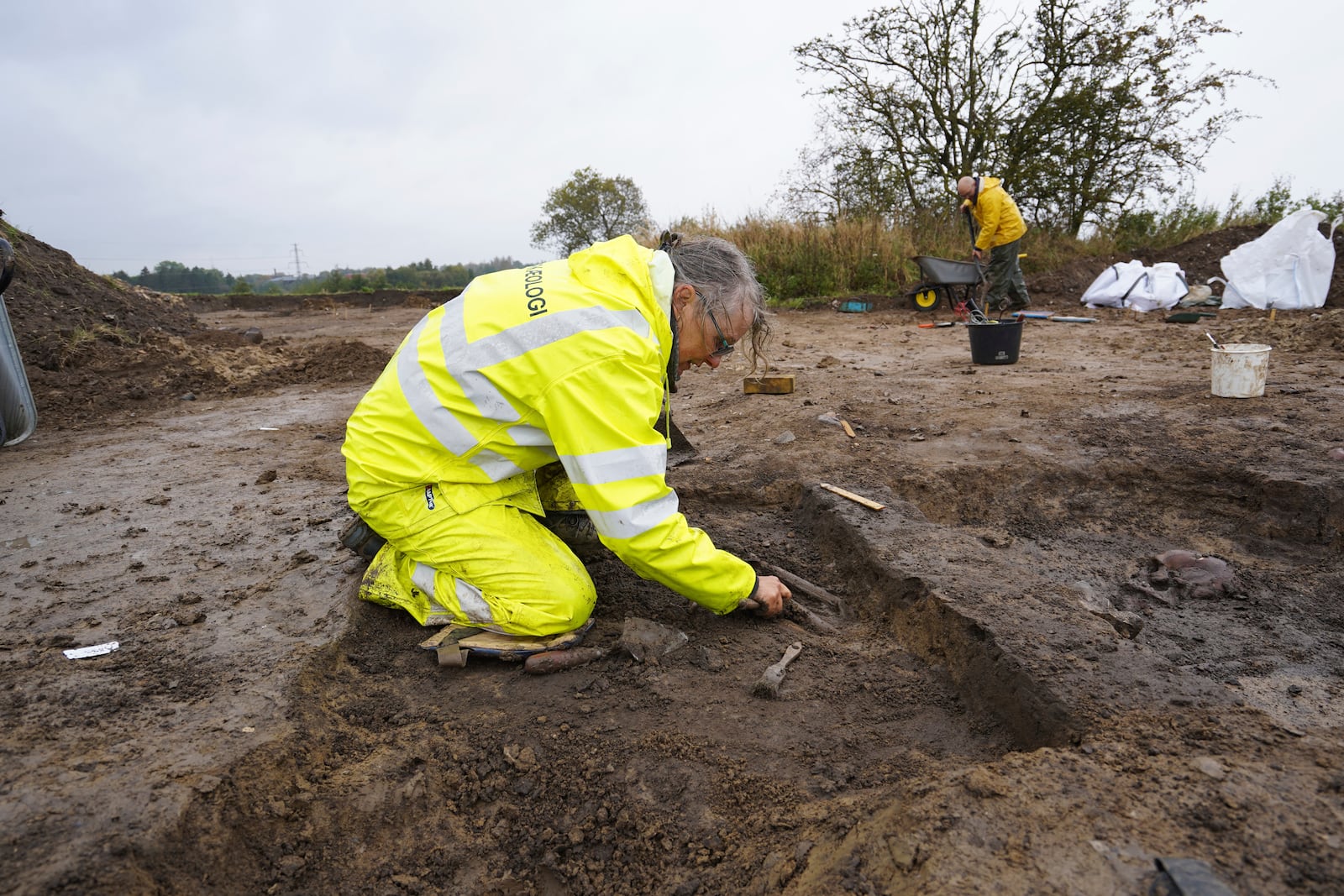 Kirsten Prangsgaard, archaeologist at Museum Odense, works at an excavation site of a 10th century Viking burial ground in Aasum, Denmark, Monday, Oct. 7, 2024. (AP Photo/James Brooks)