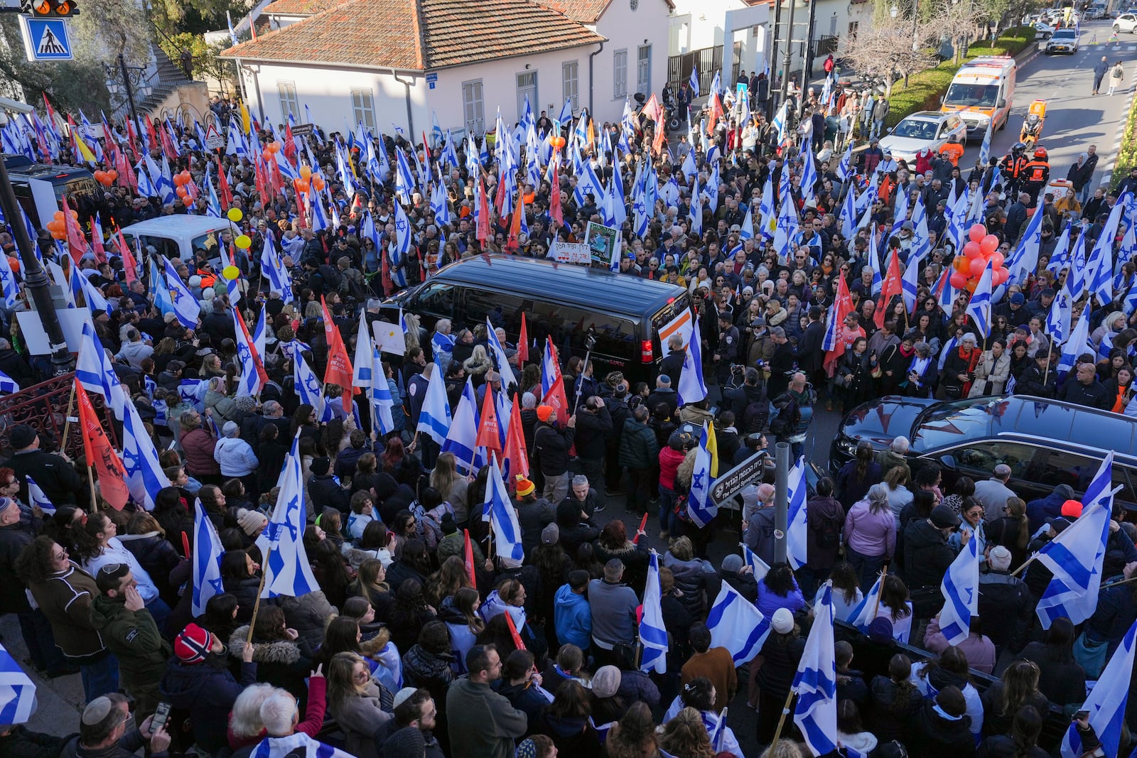 Mourners gather around the convoy carrying the coffins of slain hostages Shiri Bibas and her two children, Ariel and Kfir, during their funeral procession in Rishon Lezion, Israel, Wednesday, Feb. 26, 2025. The mother and her two children were abducted by Hamas on Oct. 7, 2023, and their remains were returned from Gaza to Israel last week as part of a ceasefire agreement with Hamas. (AP Photo/Ariel Schalit)