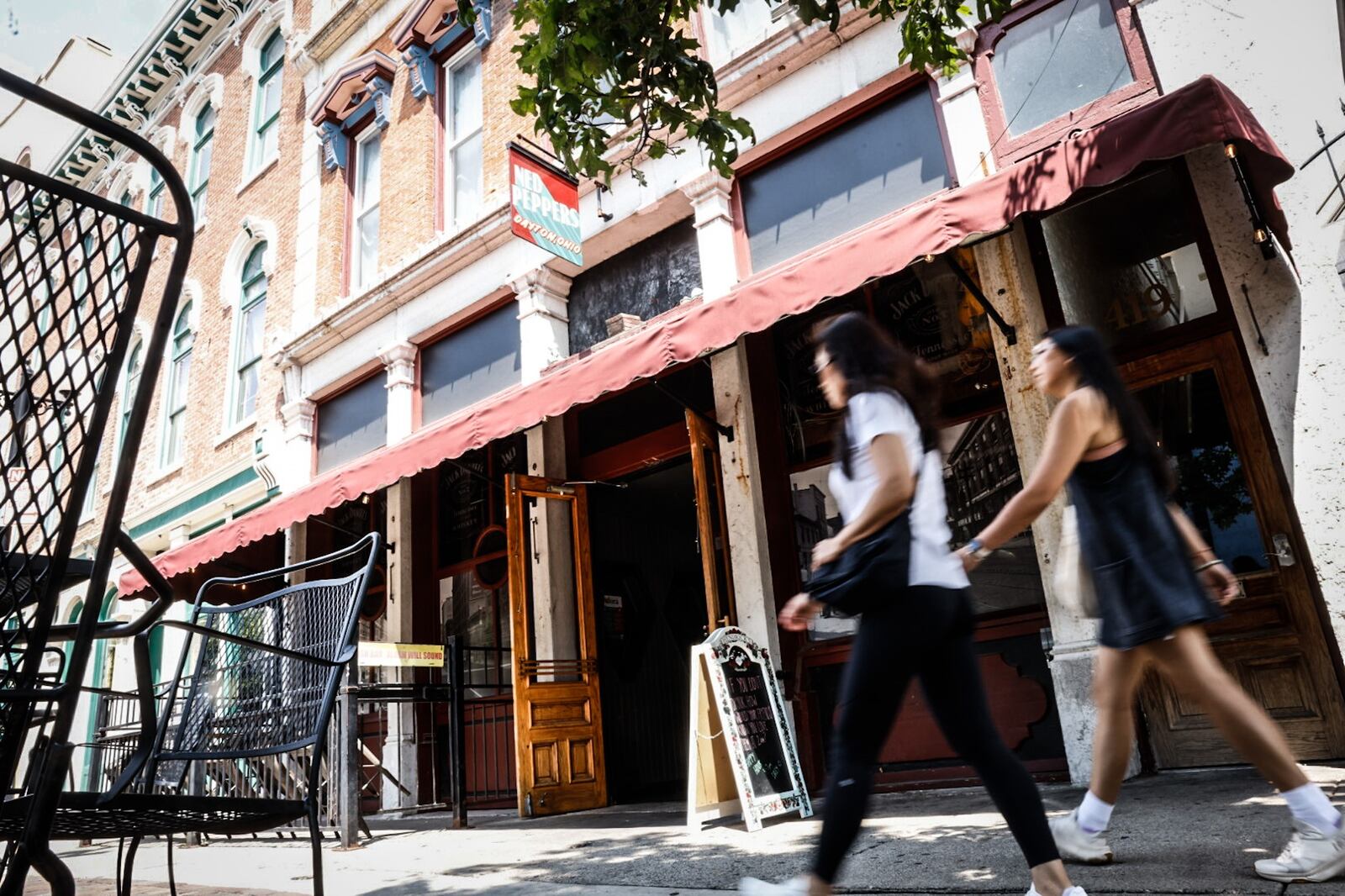 Pedestrians walk by Ned Peppers bar in the Oregon District Tuesday July 30, 2024. Today, Sunday Aug. 4, is the five-year anniversary of the mass shooting that took place on the street in front of Ned's and a couple of other bars. JIM NOELKER/STAFF