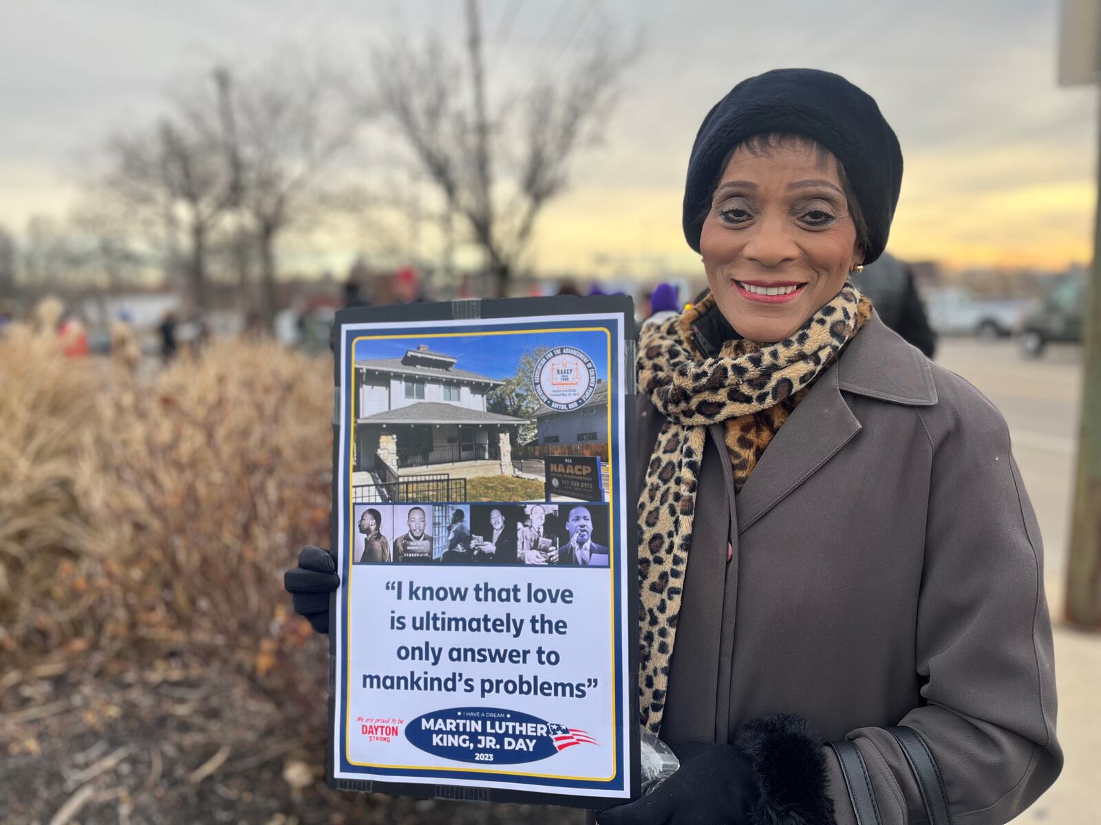 Carol Prewitt, 69, of Huber Heights, holds a sign before the Martin Luther King Day march in Dayton. The march on Jan. 16, 2023, went from West Dayton to Sinclair Community College. CORNELIUS FROLIK / STAFF