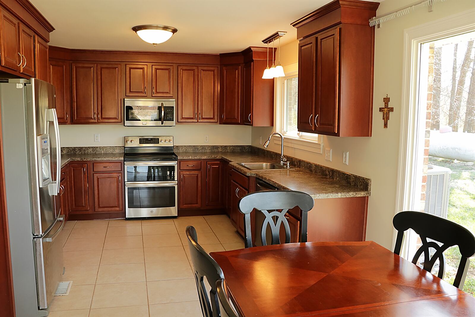 Off the great room and separated by flooring treatment are the kitchen and breakfast room. Another floor-to-ceiling window adds natural light into the breakfast room. CONTRIBUTED PHOTO BY KATHY TYLER