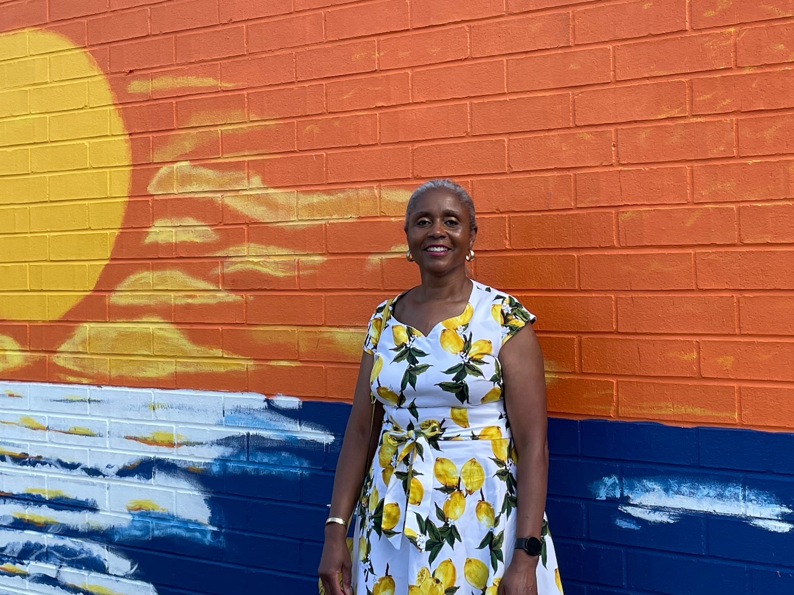 Regina Dixon, a Dayton-based artist who designed the latest Montgomery County Prevention Coalition suicide prevention mural, poses in front of the finished mural on June 27, 2024. SAM WILDOW\STAFF