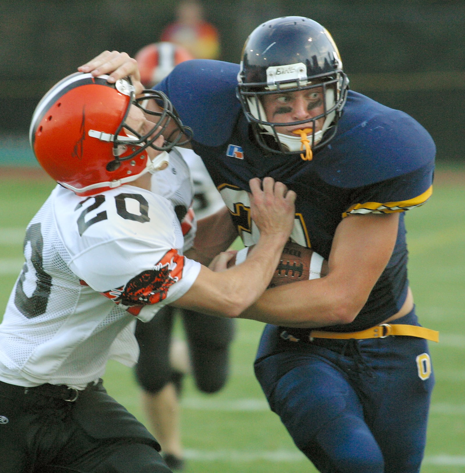 Oakwood's Nick Lewis (31) tries to keep Versailles' matt Murphy at bay during a game in 2004. DDN FILE