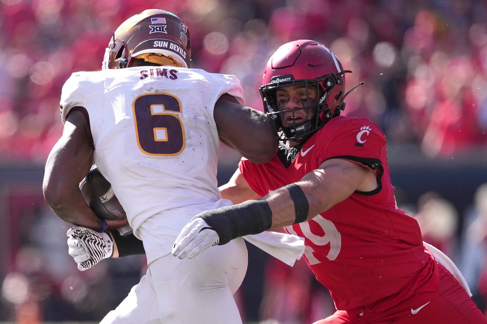 Cincinnati's Jack Dingle, right, tackles Arizona State's Jeff Sims, left, during the second half of an NCAA college football game, Saturday, Oct. 19, 2024, in Cincinnati. (AP Photo/Kareem Elgazzar)