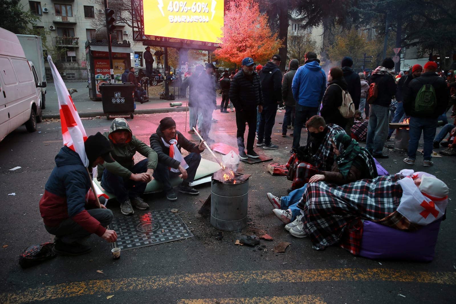 Protesters warm themselves at a bonfire during a rally against the results of the parliamentary elections amid allegations that the vote was rigged in Tbilisi, Georgia, early Monday, Nov. 18, 2024. (AP Photo/Zurab Tsertsvadze)