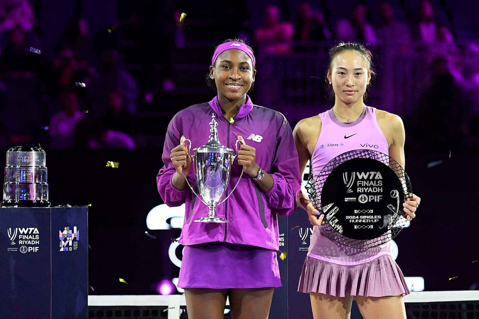 Winner Coco Gauff of the U.S., left, and runner-up China's Qinwen Zheng hold their trophies after their women's singles final match of the WTA finals at the King Saud University Indoor Arena, in Riyadh, Saudi Arabia, Saturday, Nov. 9, 2024. (AP Photo)