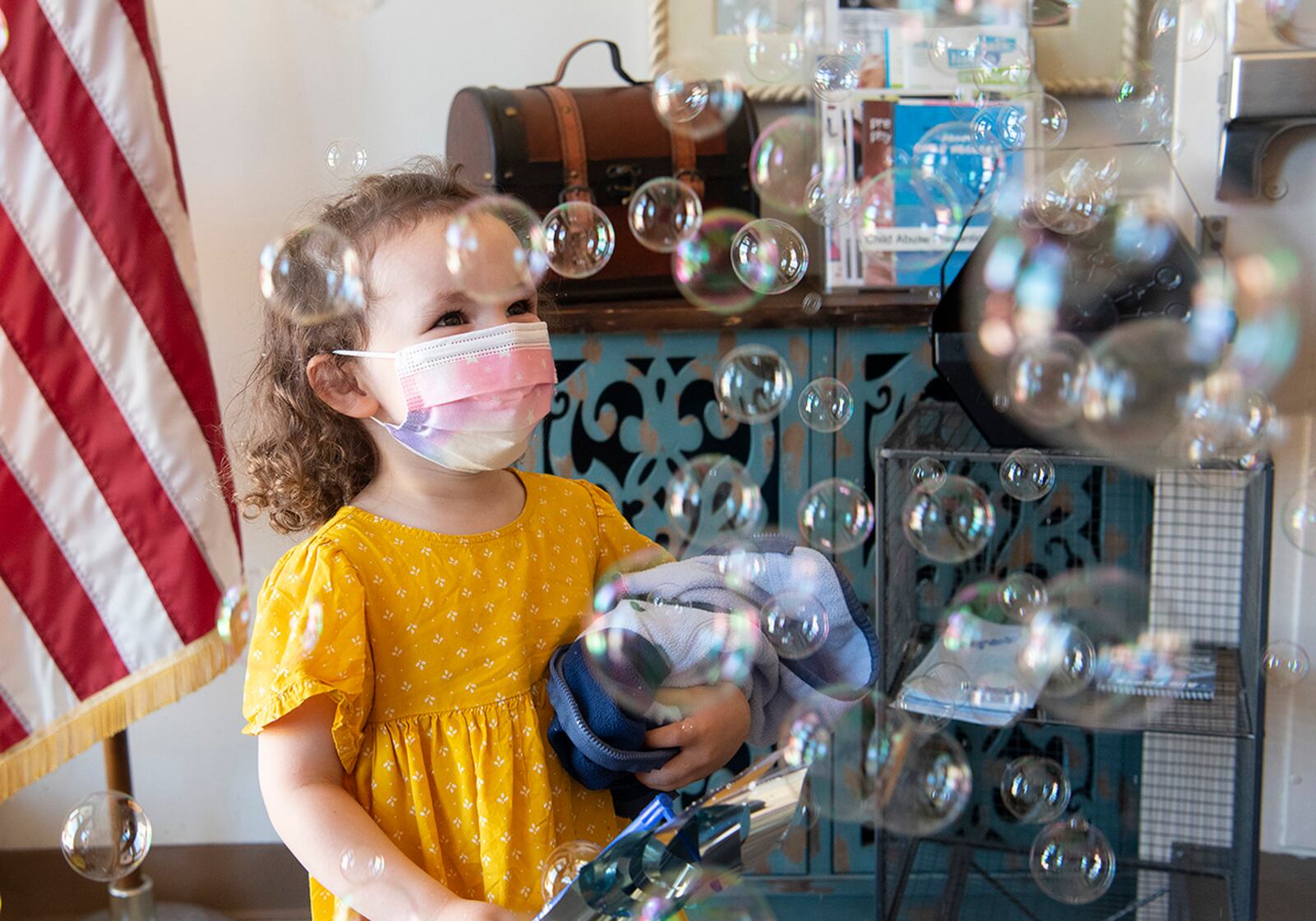 Lena Aguirre, daughter of Tech. Sgt. Pamela Aguirre, 88th Healthcare Operations Squadron, walks through bubbles April 30 as she departs the New Horizons Child Development Center on Wright-Patterson Air Force Base. U.S. AIR FORCE PHOTO/R.J. ORIEZ