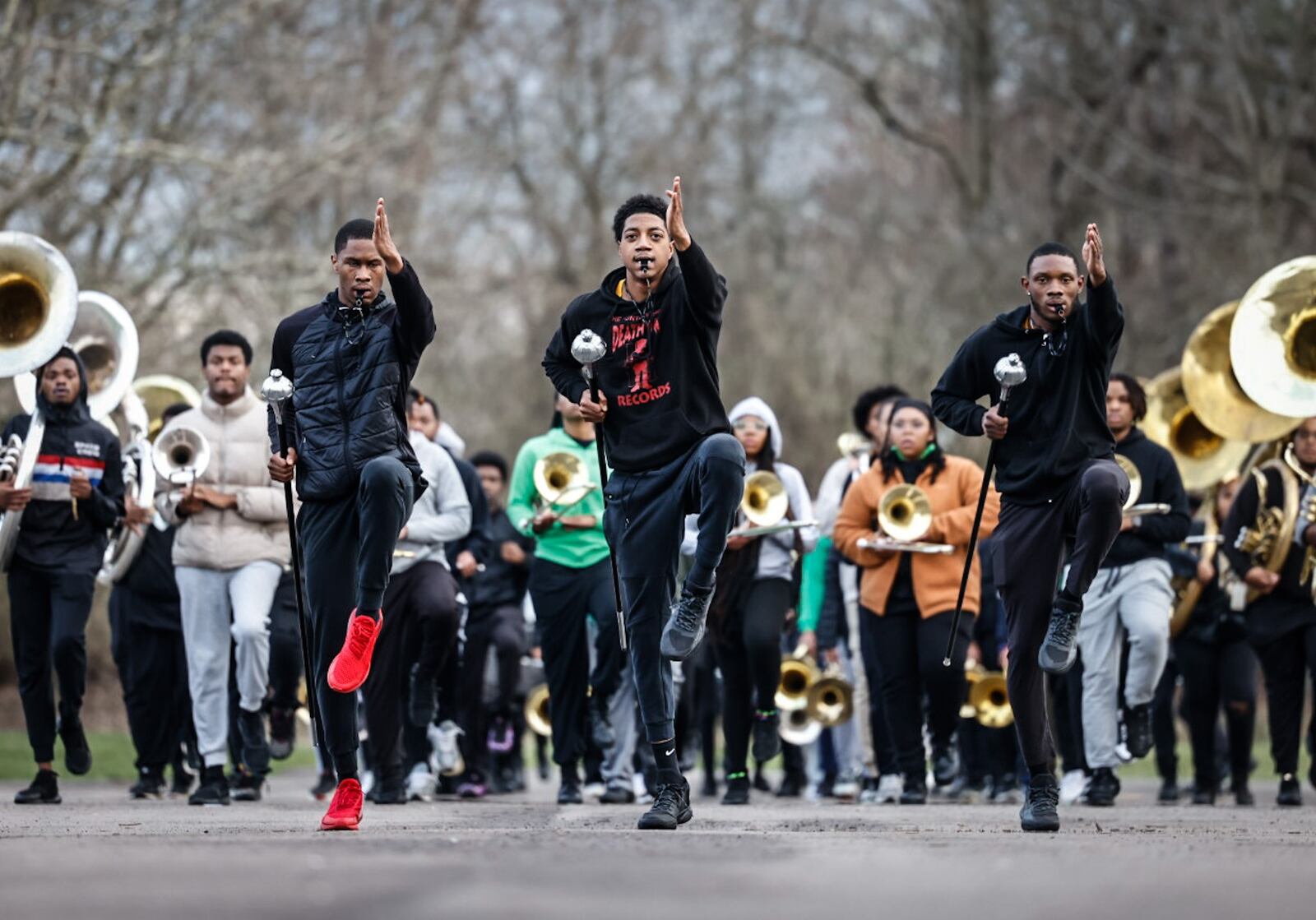 From left, Jordan Harris, Joni Bargaineer and Tayshawn Gaines lead the band while practicing for the Cincinnati Reds Opening Day Parade in the parking lot at Wilberforce University. JIM NOELKER/STAFF