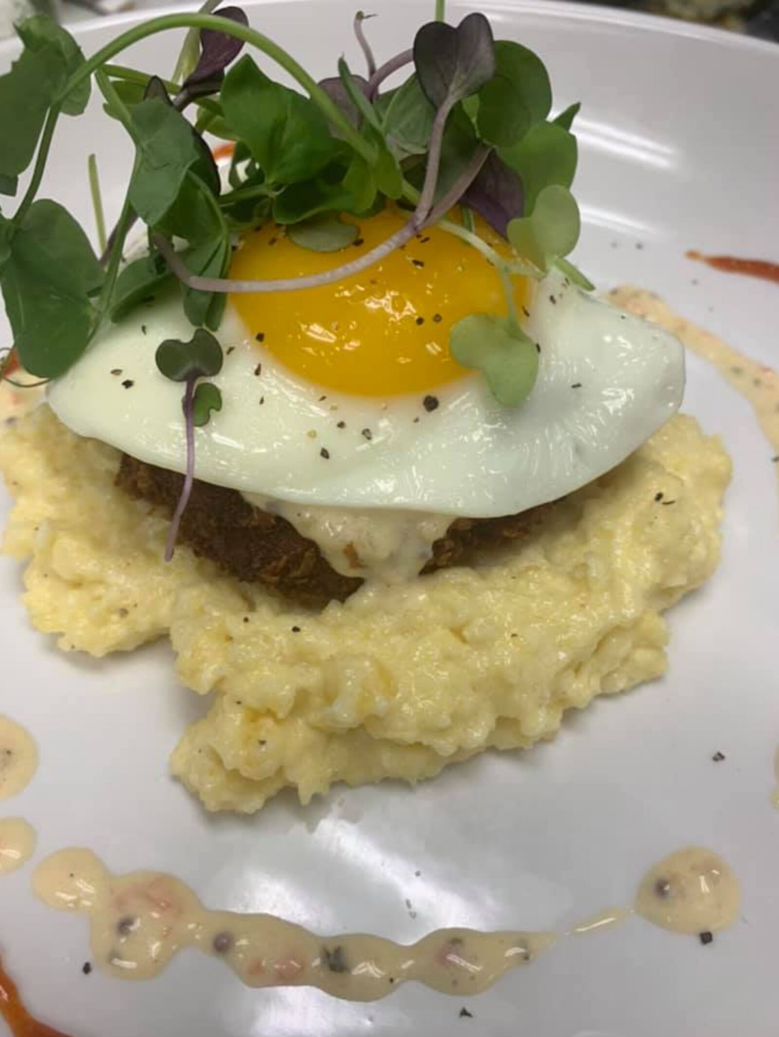 Watermark Restaurant's new brunch features a crispy crab cake atop smoked Gouda grits with Dijon cream sauce and a sunny side up egg. (Source: Watermark Facebook)