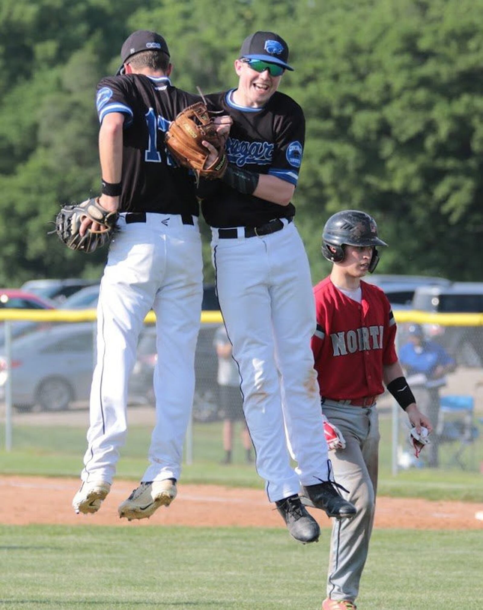 Cincinnati Christian’s Alex Johnson (17) and Caden Glenn (right) celebrate after the Cougars beat Tri-County North 3-1 in a Division IV district baseball final at Carlisle on Friday. PHOTO BY KRAE/WWW.KRAEPHOTOGRAPHY.COM