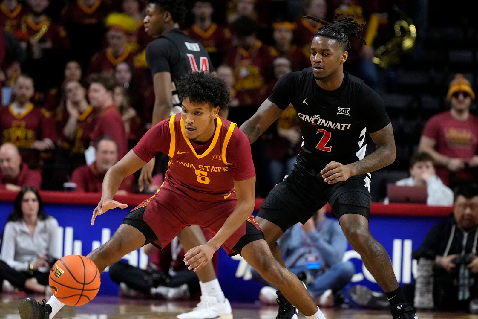 Iowa State guard Curtis Jones (5) runs down a loose ball ahead of Cincinnati guard Jizzle James (2) during the first half of an NCAA college basketball game Saturday, Feb. 15, 2025, in Ames, Iowa. (AP Photo/Charlie Neibergall)