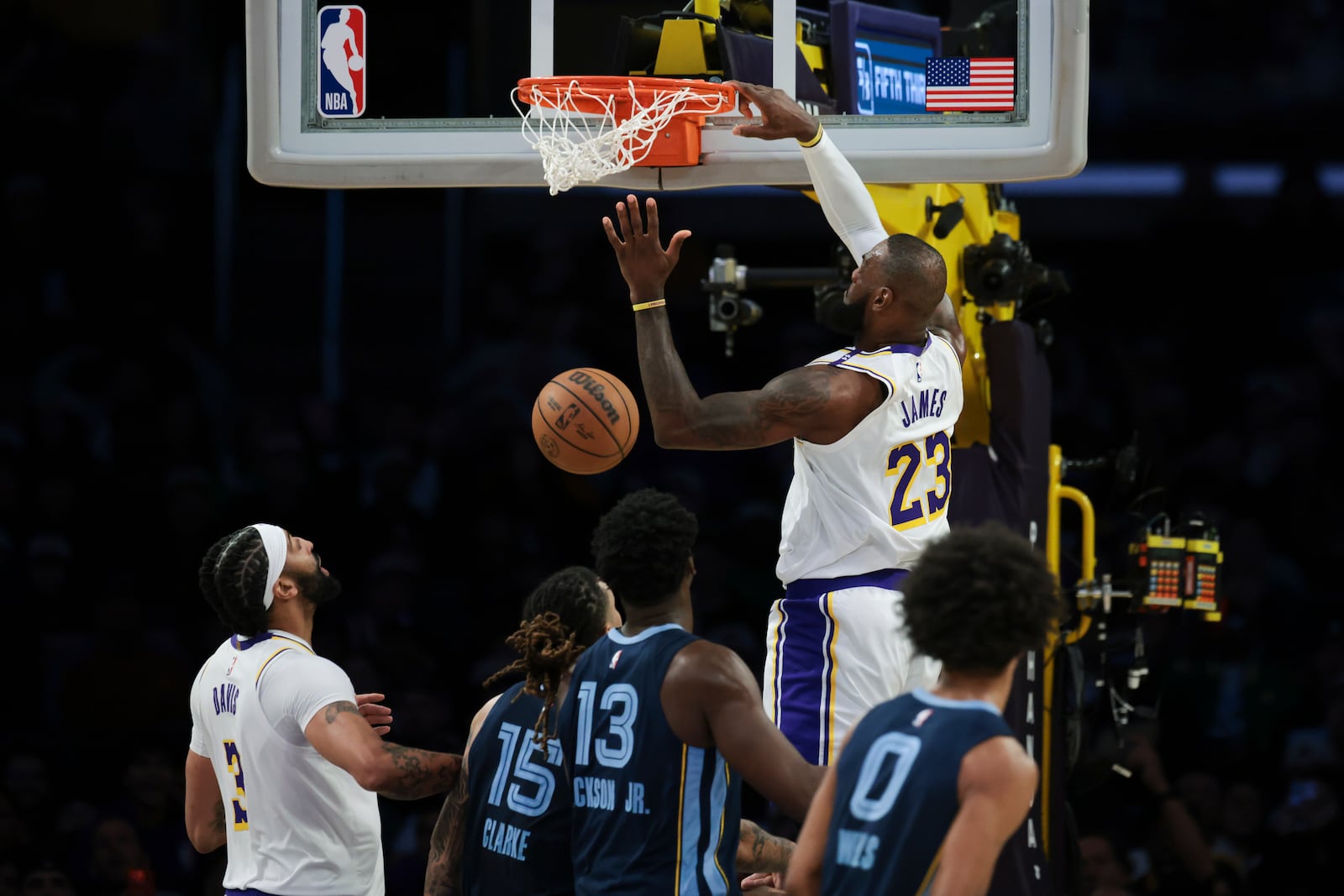 Los Angeles Lakers forward LeBron James (23) dunks the ball as forward Anthony Davis (3), Memphis Grizzlies forward Brandon Clarke (15), forward Jaren Jackson Jr. (13), forward Brandon Clarke (15) and forward Jaylen Wells (0) watch during the first half of an NBA basketball game, Sunday, Dec. 15, 2024, in Los Angeles. (AP Photo/Jessie Alcheh)