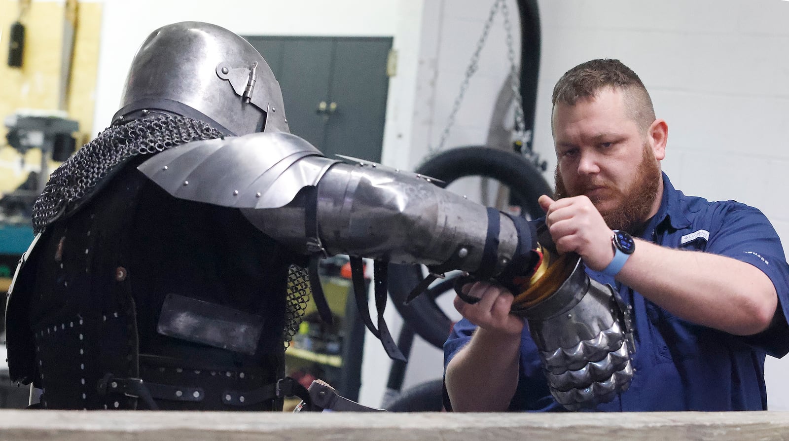 Travis Young (right) squires for Gabriel Hutchings as he suits up before a Cincinnati Barbarians practice Thursday, Feb. 13, 2025. MARSHALL GORBY\STAFF