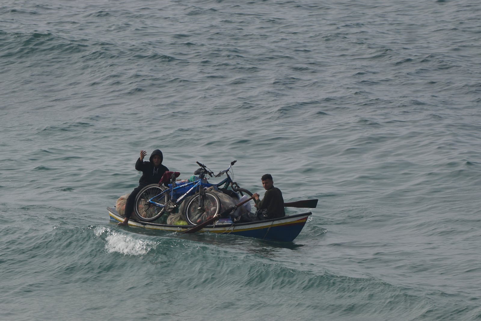 Displaced Palestinians ride on a boat in the Mediterranean Sea as they return to their homes in the northern Gaza Strip, Tuesday, Jan. 28, 2025. (AP Photo/Abdel Kareem Hana)