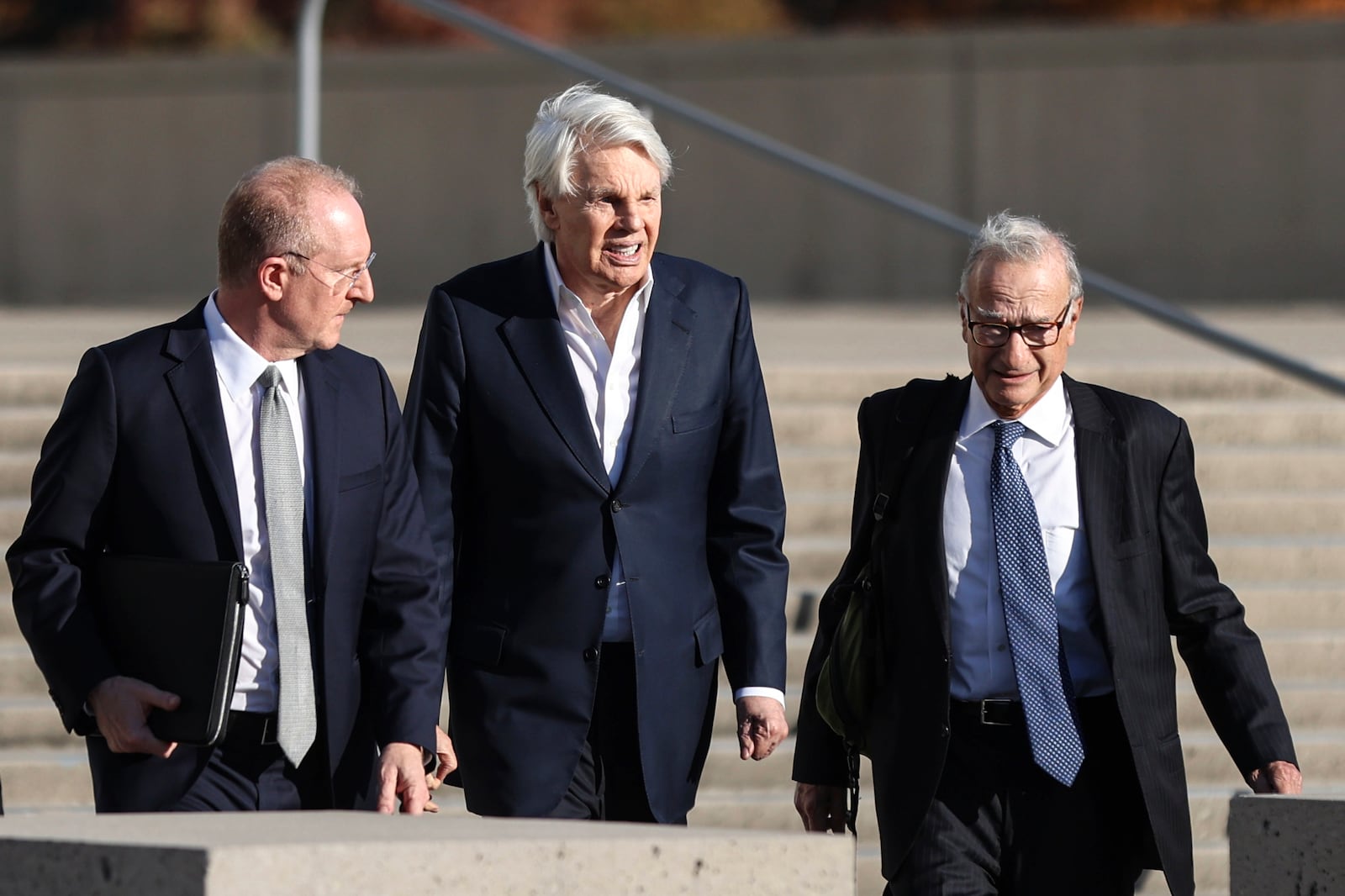 Michael Jeffries, former CEO of Abercrombie & Fitch, center, exits the federal courthouse after his arraignment on sex trafficking and interstate prostitution charges, Friday, Oct. 25, 2024, in Central Islip, N.Y. (AP Photo/Heather Khalifa)