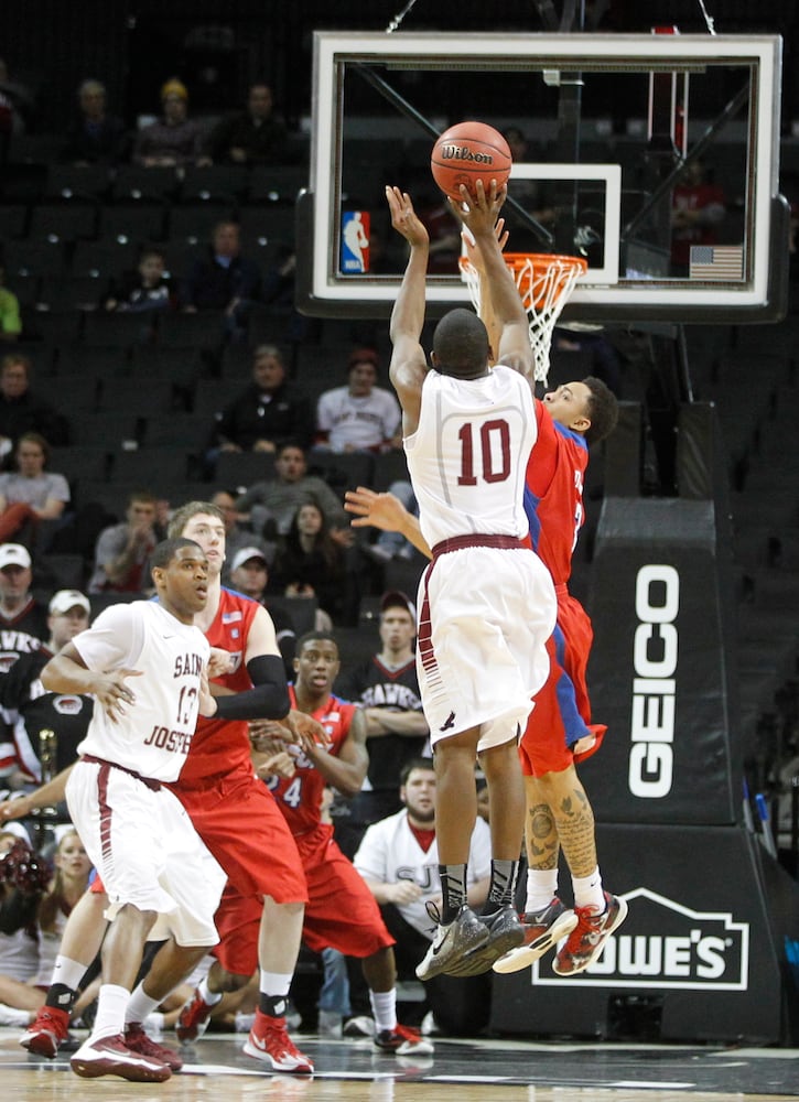 Saint Joseph's Langston Galloway, front, hits the game-winning shot with 19 seconds left over Dayton's Kyle Davis in the quarterfinals of the A-10 tournament on Friday, March 14, 2014, at the Barclays Center in Brooklyn, N.Y. David Jablonski/Staff