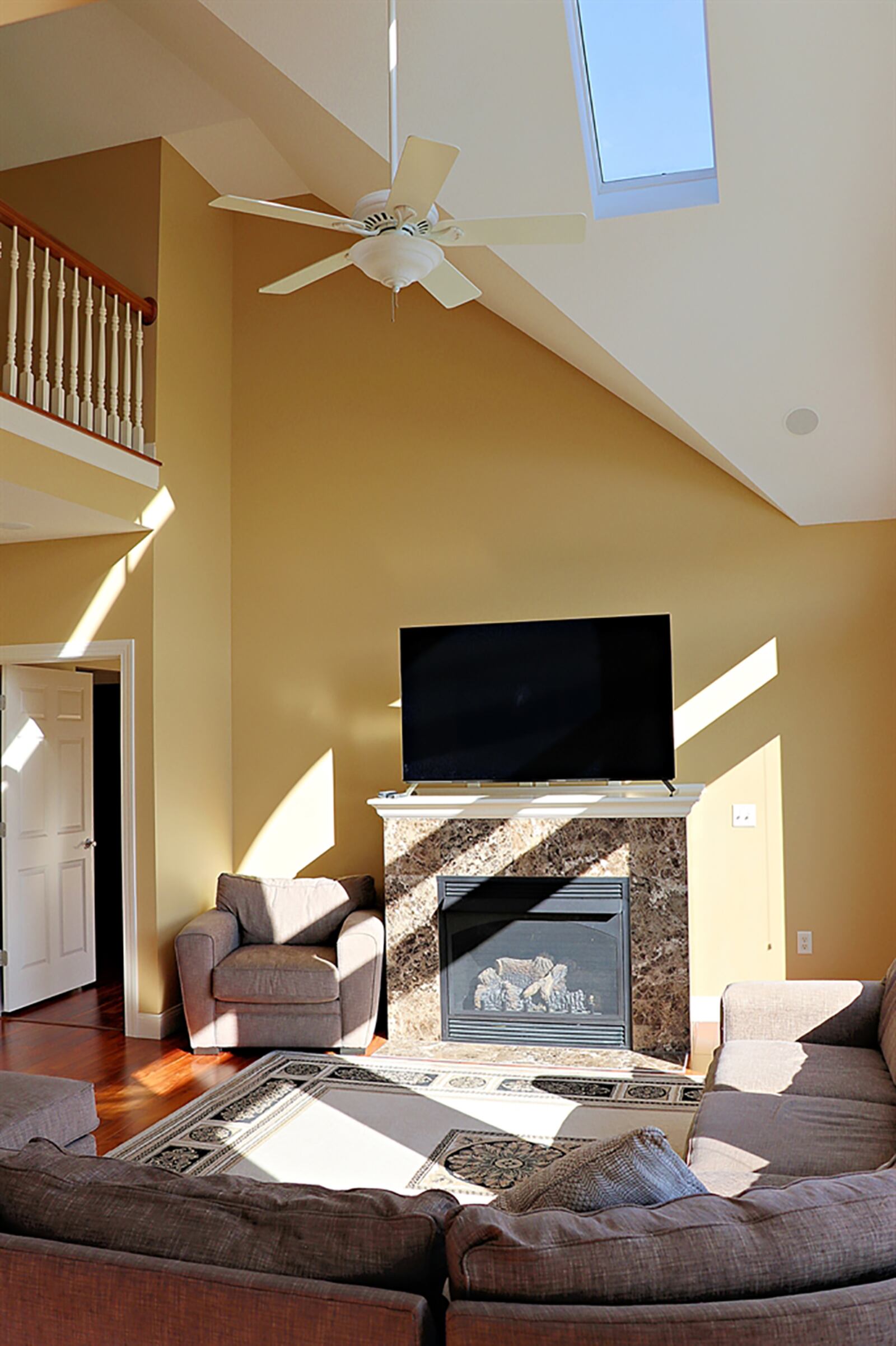 A gas fireplace extends into the great room and has a stone surround and wood-cap mantel. CONTRIBUTED PHOTO BY KATHY TYLER