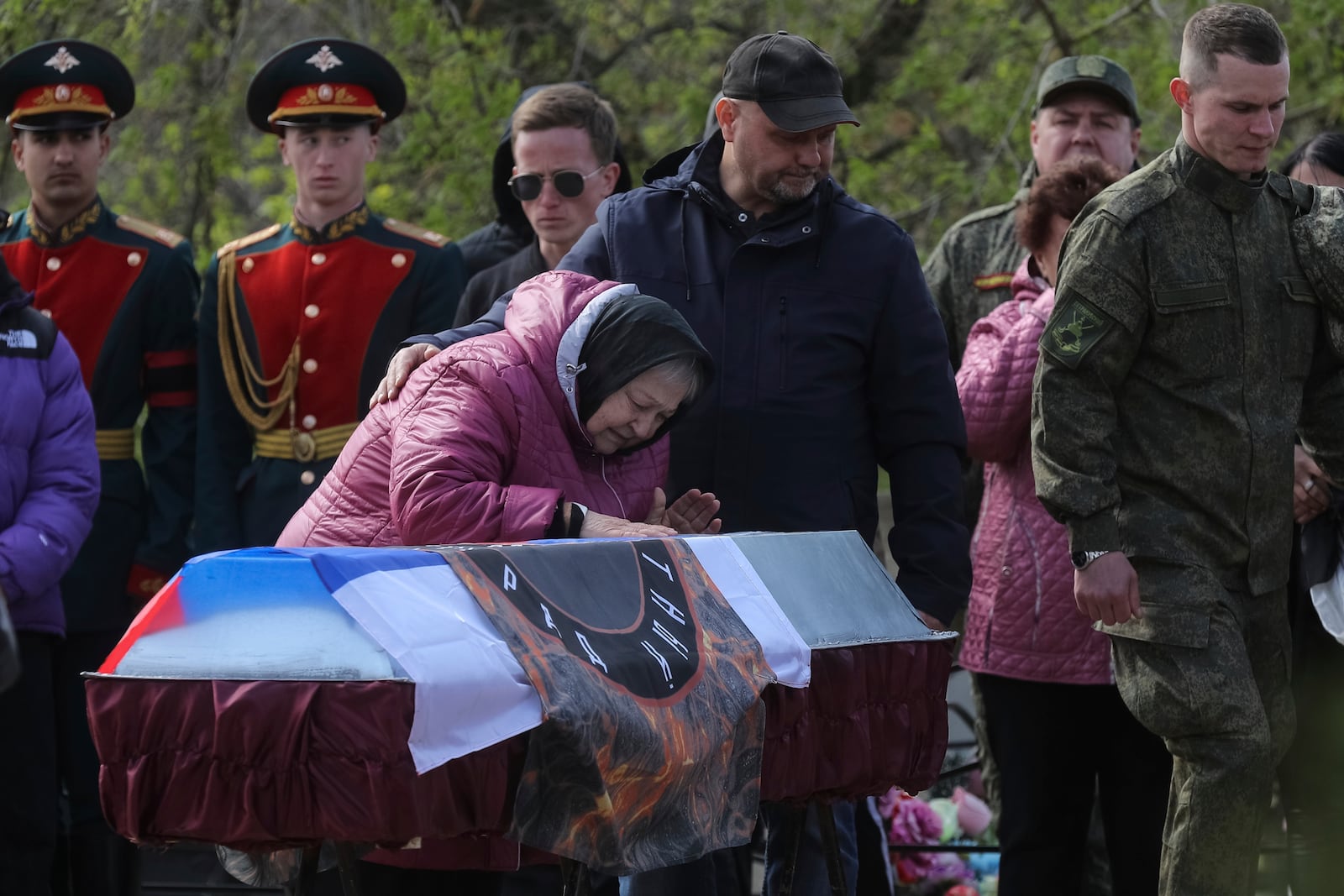 FILE - A relative of Shashkov Savely, a volunteer of detachment "Immortal Stalingrad" in the Russian Army, who was killed during a Russian special military operation in Ukraine, pays her last respect during his farewell ceremony at a cemetery in Krasnoslobodsk, Volgograd region, Russia, Saturday, April 15, 2023. (AP Photo, File)