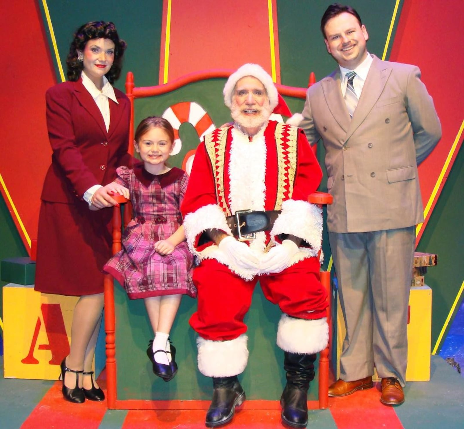 (Left to right): La Comedia Dinner Theatre's production of "Miracle on 34th Street: The Musical" features Rebecca Lea Evans (Doris), Adilynn Hatton (Susan), Jonathan Fluck (Kris Kringle), and Keenan Patrick Buckley (Fred). PHOTO BY JUSTIN WALTON