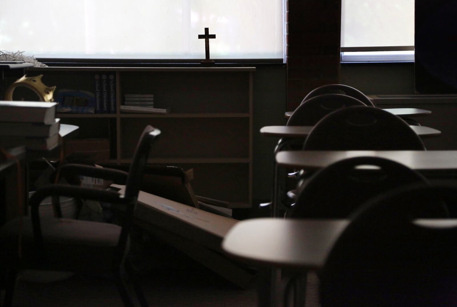 FILE - In this Monday, June 8, 2020 file photo, a cross sits in the window of an empty classroom at Quigley Catholic High School in Baden, Pa. (AP Photo/Jessie Wardarski)