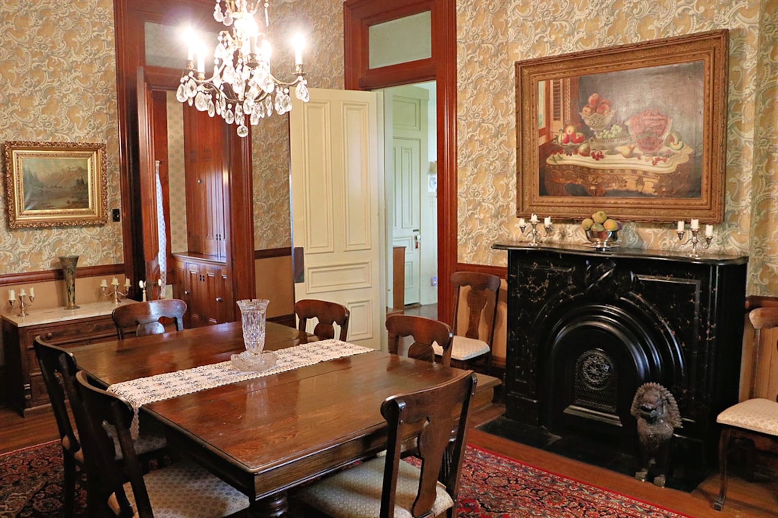 A crystal chandelier hangs above the formal dining room and two doors open into two separate butler’s pantries with built-in buffets, linen drawers and cabinetry. 