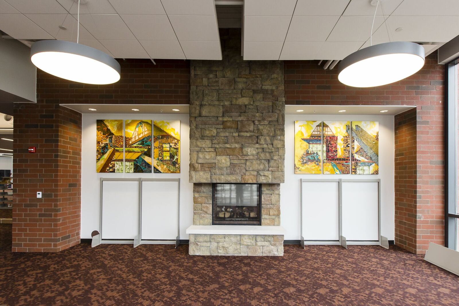 Artist Marsha Monroe Pippenger of Dayton used paper collage and mixed media for her work, “Spaces Between Stone. ” It flanks the fireplace in the new library’s comfy reading lounge. CONTRIBUTED/ANDY SNOW