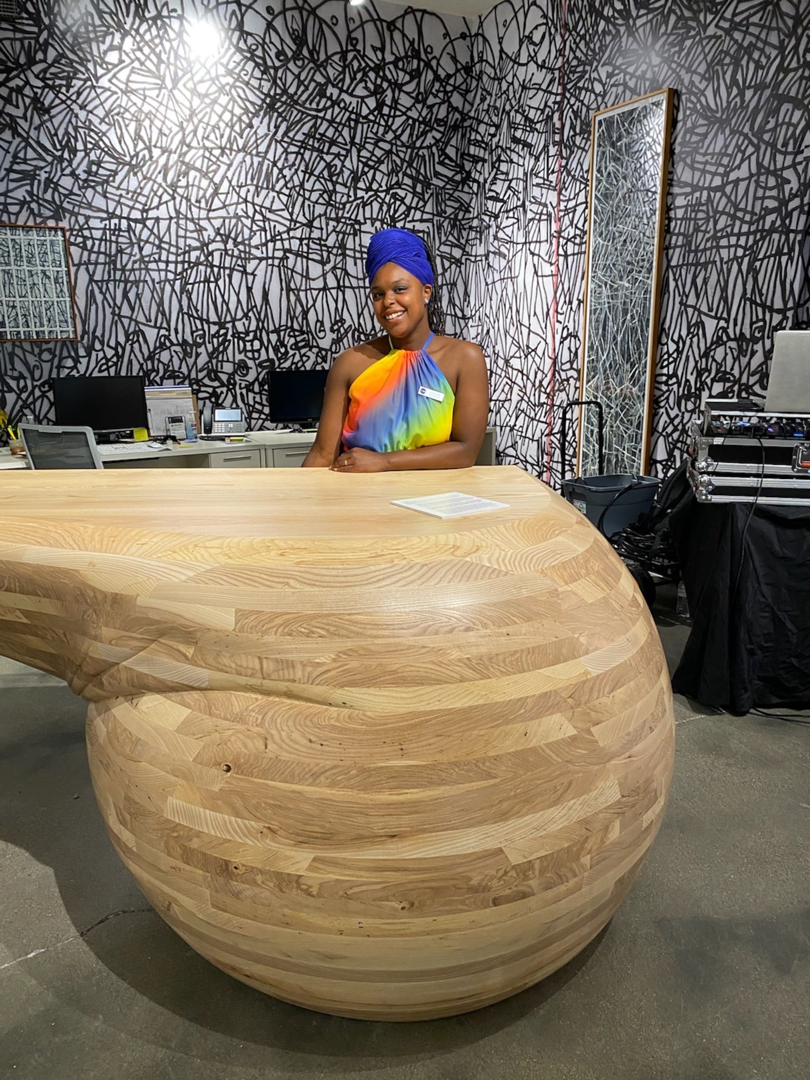 Curatorial Assistant Cydnie King sits behind the desk at The Contemporary Dayton.