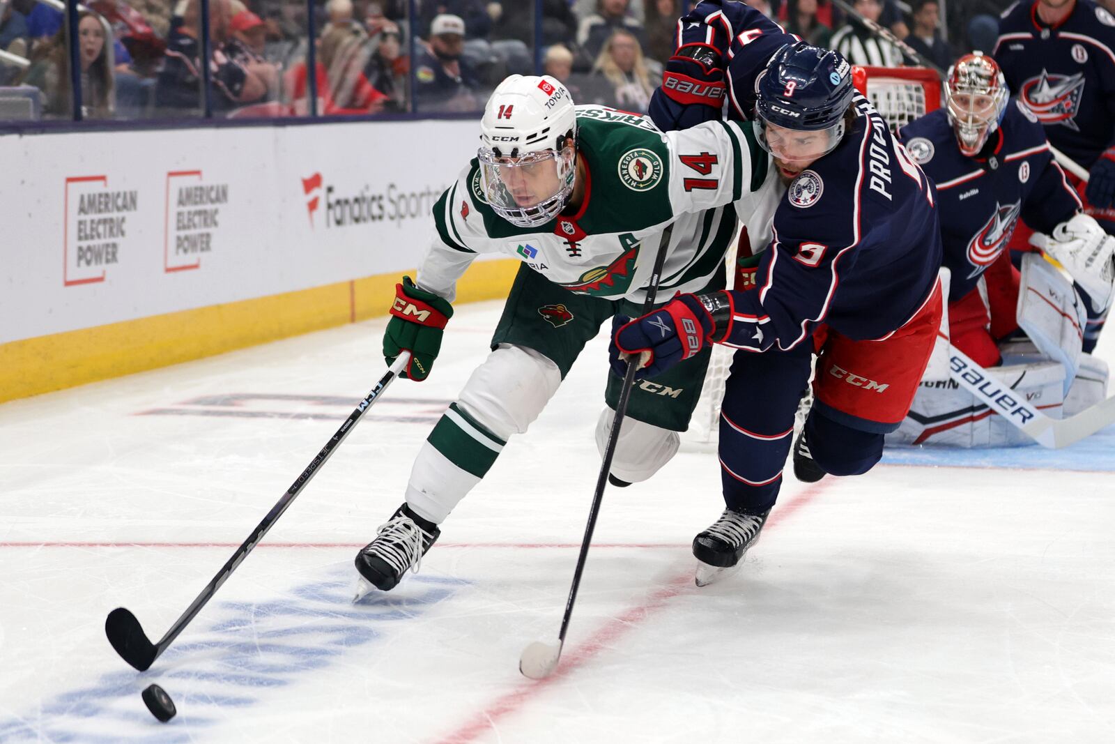 Minnesota Wild forward Joel Eriksson Ek, left, reaches for the puck in front of Columbus Blue Jackets defenseman Ivan Provorov during the first period of an NHL hockey game in Columbus, Ohio, Saturday, Oct. 19, 2024. (AP Photo/Paul Vernon)