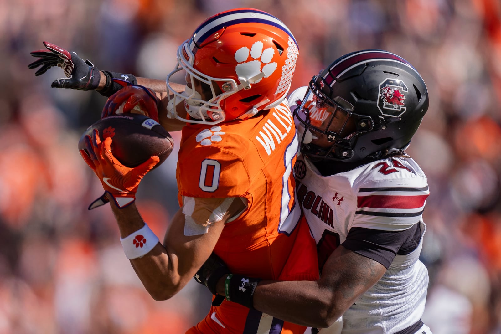 Clemson wide receiver Antonio Williams (0) catches a pass while defended by South Carolina defensive back Jalon Kilgore (24) in the first half of an NCAA college football game Saturday, Nov. 30, 2024, in Clemson, S.C. (AP Photo/Jacob Kupferman)