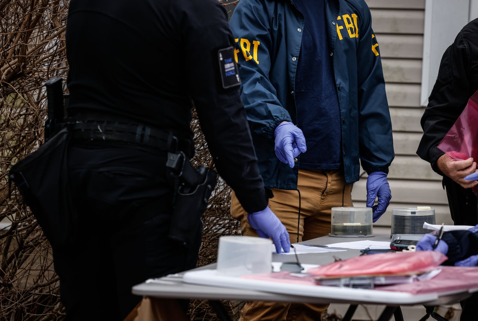 FBI agents had a table set up outside a Fairborn home on Pat Lane with blank CDs as part of an investigation on Thursday, Dec. 16, 2021. JIM NOELKER / STAFF