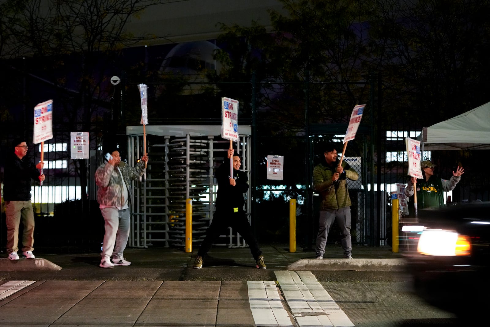 Boeing employees cheer and wave picket signs as a driver honks in support after a majority of union members voted to reject a new contract offer from the company, Wednesday, Oct. 23, 2024, in Renton, Wash. (AP Photo/Lindsey Wasson)