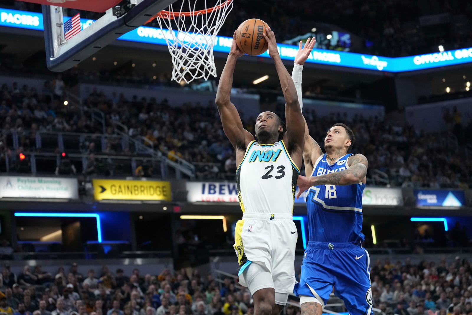 Indiana Pacers forward Aaron Nesmith (23) shoots in front of Milwaukee Bucks forward Kyle Kuzma (18) during the second half of an NBA basketball game in Indianapolis, Tuesday, March 11, 2025. (AP Photo/AJ Mast)