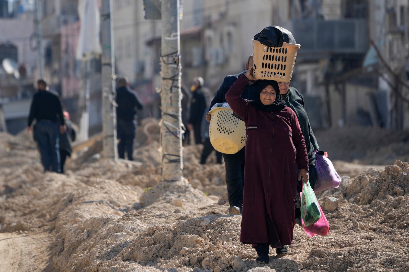 Residents of the West Bank urban refugee camp of Nur Shams evacuate their homes and carry their belongings as the Israeli military continues its operation in the area on Wednesday, Feb. 26, 2025. (AP Photo/Majdi Mohammed)