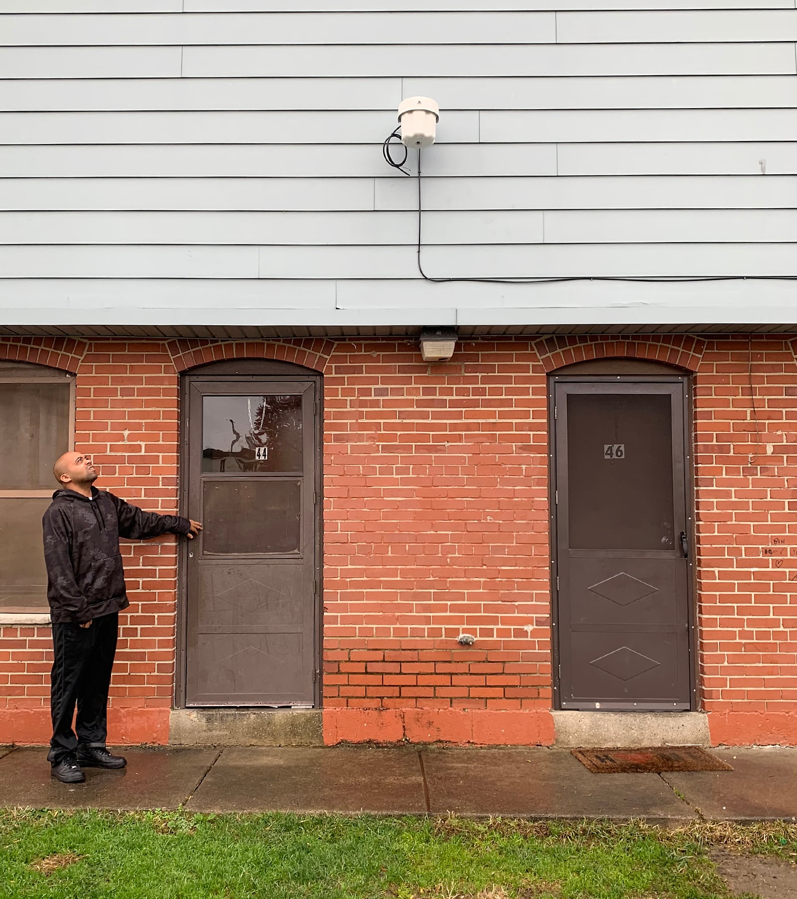 Robert Ward looks up at an outdoor internet access point installed outside his Desoto Bass Courts apartment in Dayton. A nearly $3 million initiative will help close a digital divide by bringing broadband and computer devices to residents of five Dayton public housing complexes. CHRIS STEWART / STAFF