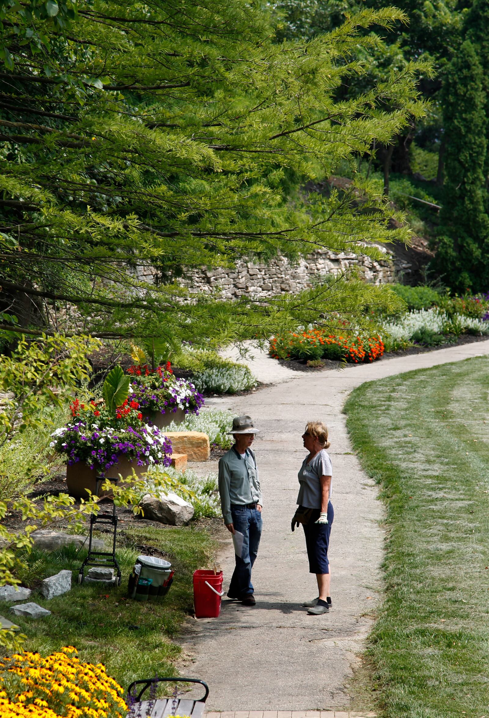 Robert Kincses (CQ), trustee with the American Veterans Heritage Center (left) and Jane Falck, a master gardener volunteer, chat along a pathway in the grotto garden on the grounds of the Dayton VA Medical Center.  Master Gardener volunteers have spent the past two years restoring the area originally developed by Union Civil War veterans. . LISA POWELL / STAFF