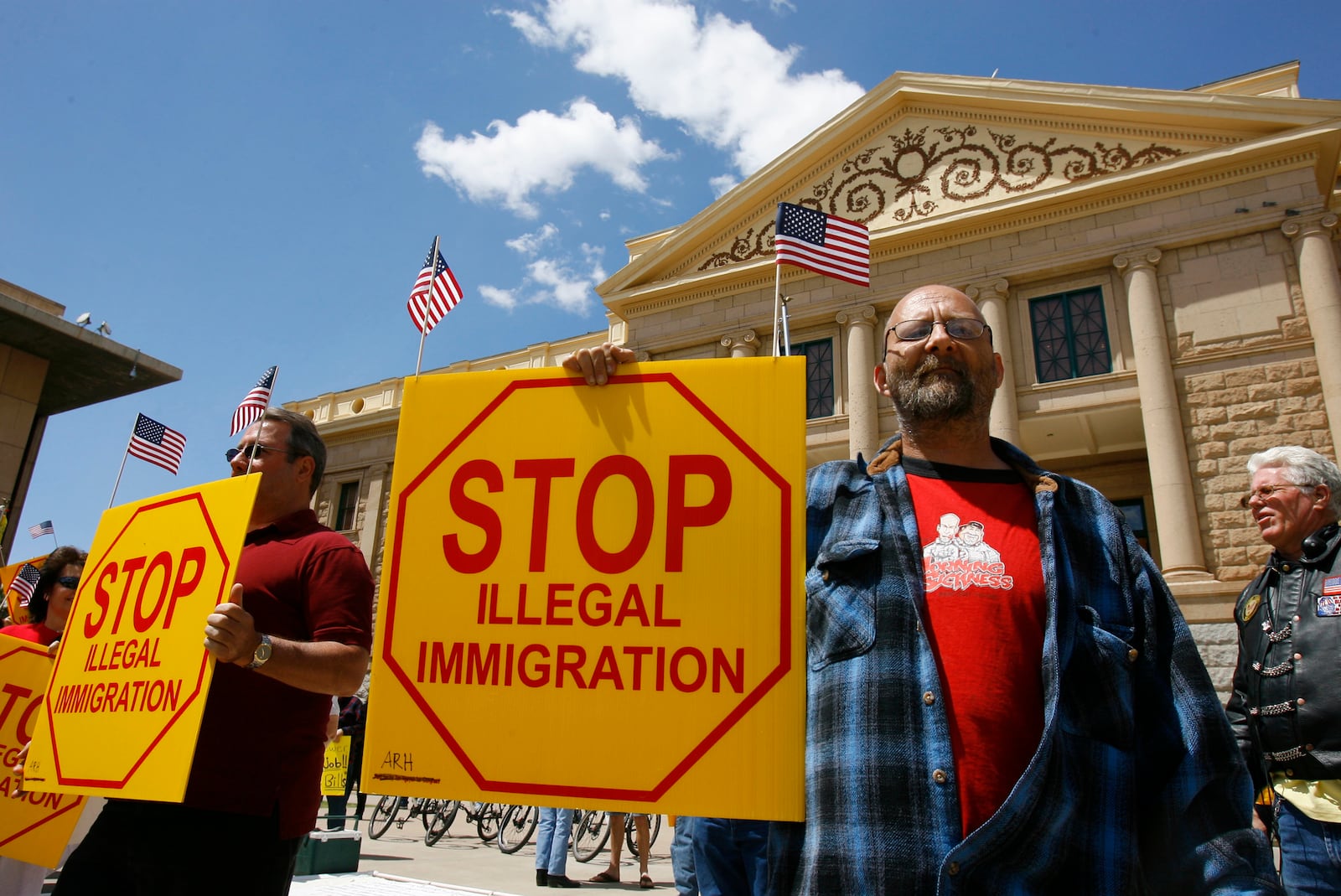 FILE - Ernie Getford holds a sign in support of the controversial SB1070 illegal immigration enforcement bill during a rally at the state Capitol in Phoenix, April 23, 2010. (Nick Oza/The Arizona Republic via AP, File)