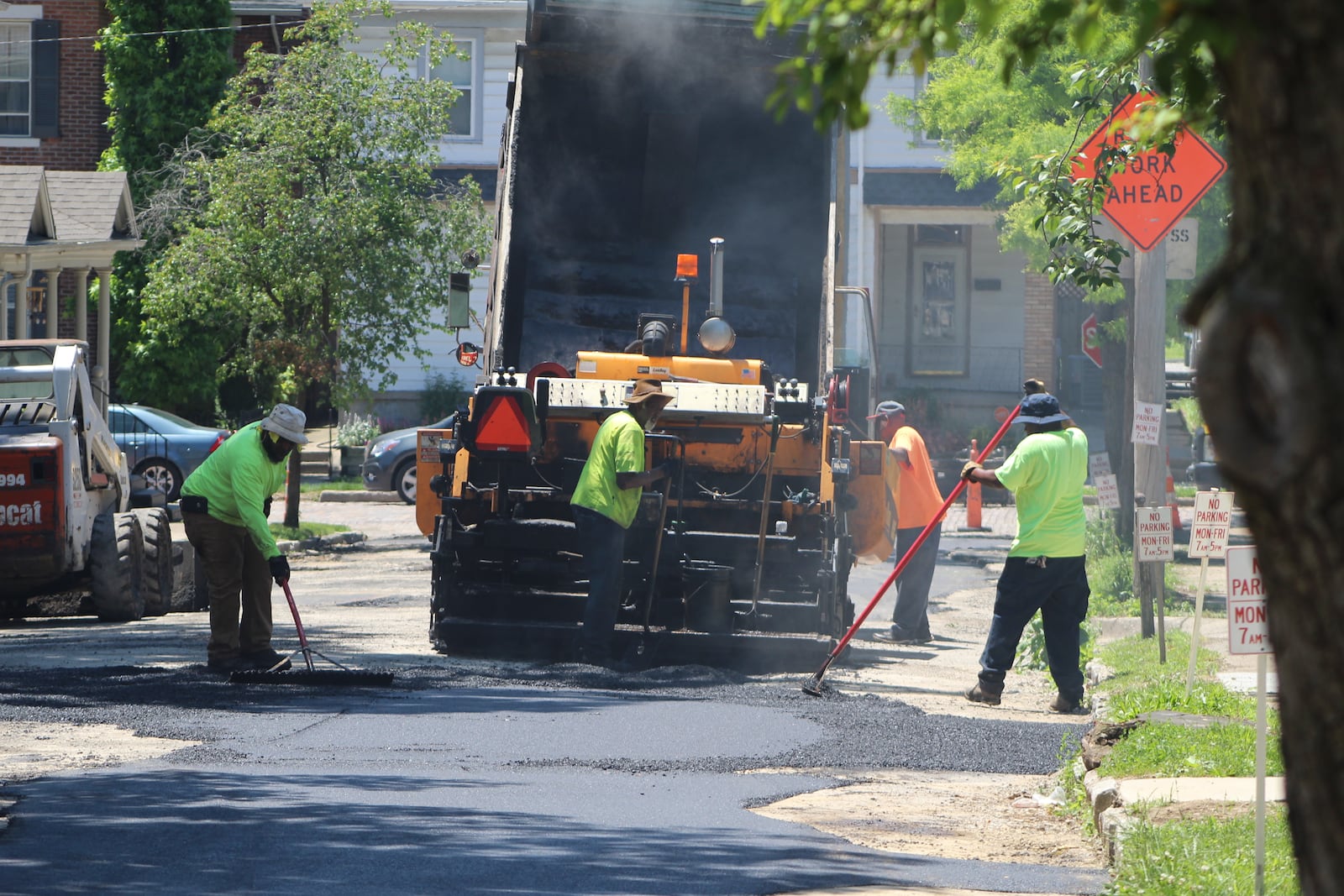 Crews lay down pavement on Garret Street in the South Park neighborhood on Friday. CORNELIUS FROLIK / STAFF