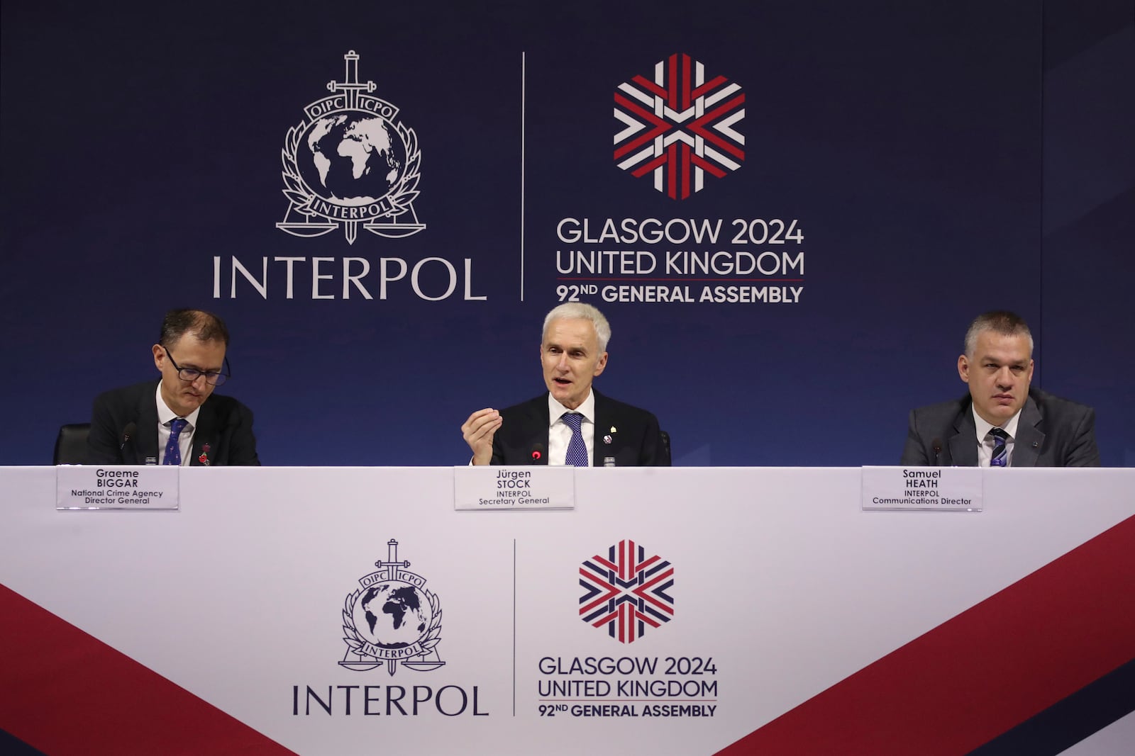 Juergen Stock Interpol secretary general, center, Graeme Biggar National crime agency director general, left, and Samuel Heath Interpol communications director, right, address the media at 92nd Interpol general assembly in Glasgow, Scotland, Monday, Nov. 4, 2024. (AP Photo/Scott Heppell)