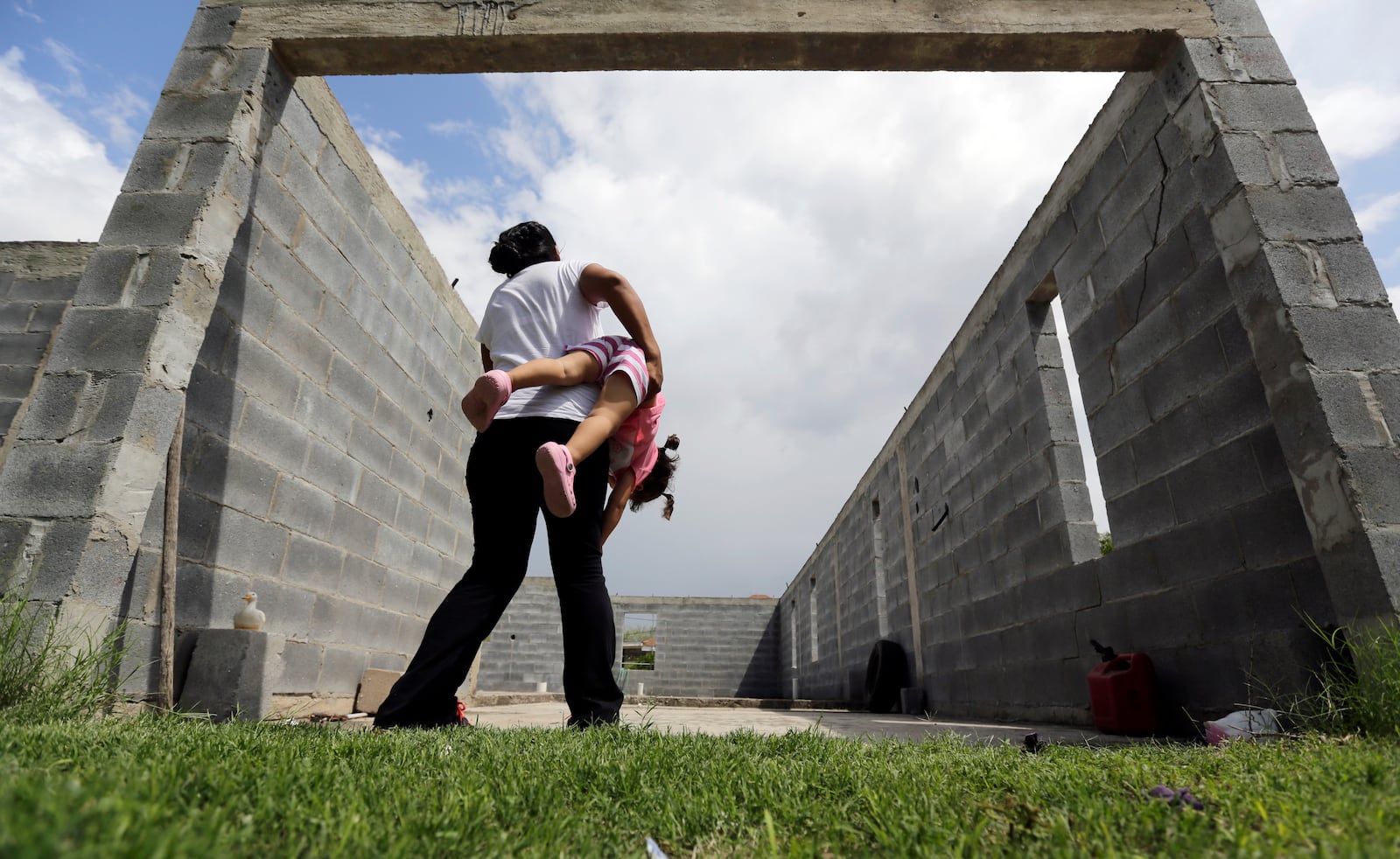 FILE - A woman in Sullivan City, Texas, who said she entered the country illegally, plays with her daughter who was born in the United States, but was denied a birth certificate, Sept. 16, 2015. (AP Photo/Eric Gay, File)