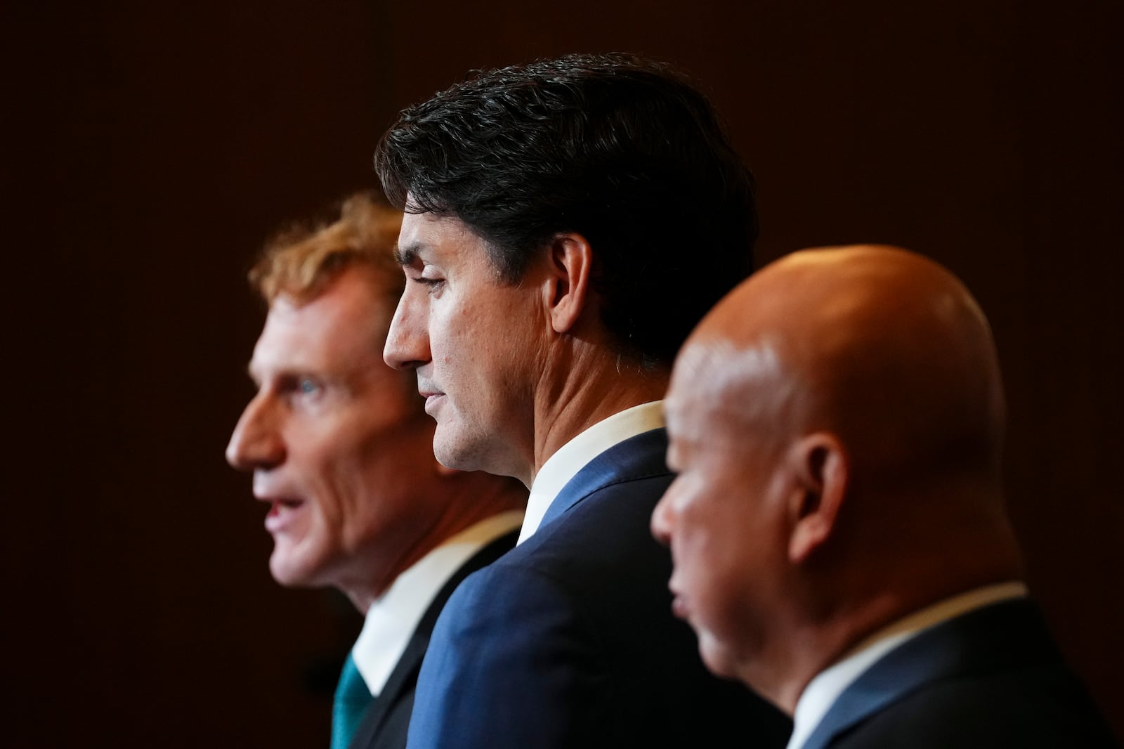 Prime Minister Justin Trudeau, center, Immigration, Refugees and Citizenship Minister Marc Miller, left, and Parliamentary Secretary to the Minister of Immigration, Refugees and Citizenship Paul Chiang hold a press conference on Parliament Hill in Ottawa Thursday, Oct. 24, 2024. (Sean Kilpatrick/The Canadian Press via AP)