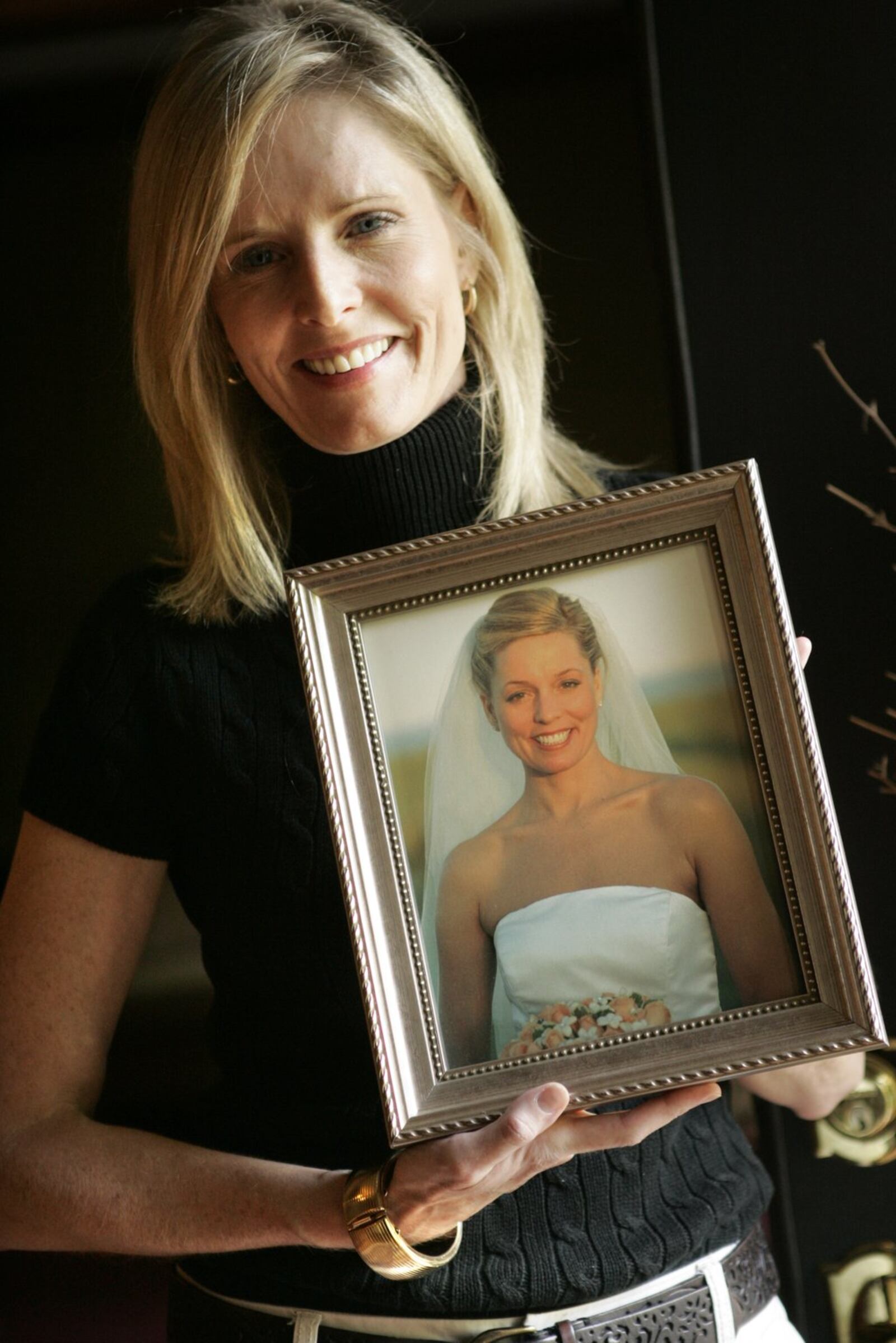 Tracy Janess of Kettering holds a portrait of her sister Kristy Irvine Ryan, a University of Dayton graduate and young bride who died in the attacks on the World Trade Center. Before her death Kristy was involved with a children’s charity known as Secret Smiles. STAFF FILE PHOTO