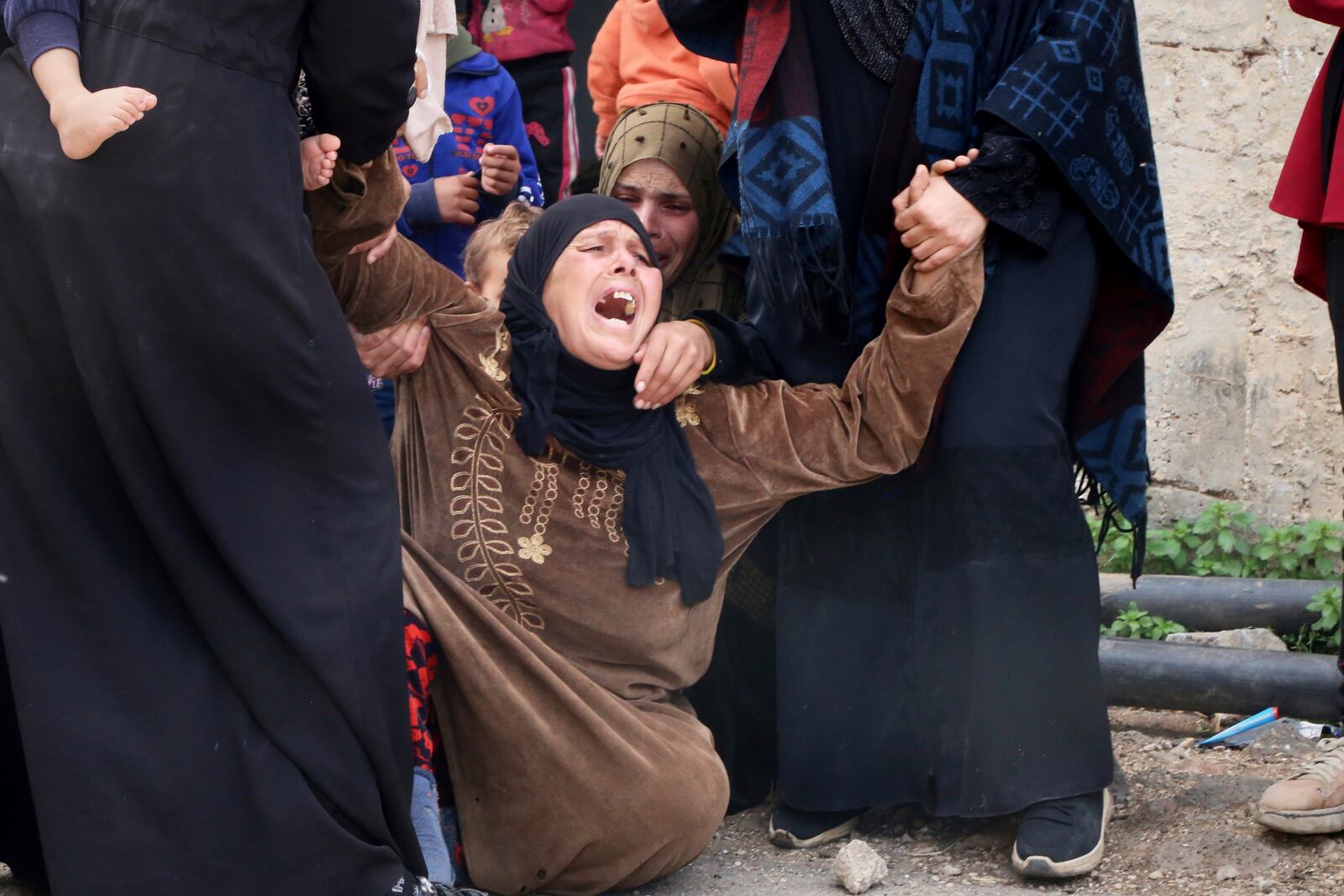 The mother of Ali Mohammad al-Hneiss, reportedly killed in an Israeli drone attack that claimed at least four lives, weeps during his funeral in the village of Koayiah, southwestern Syria, Tuesday, March 25, 2025. (AP Photo/Malek Khattab)