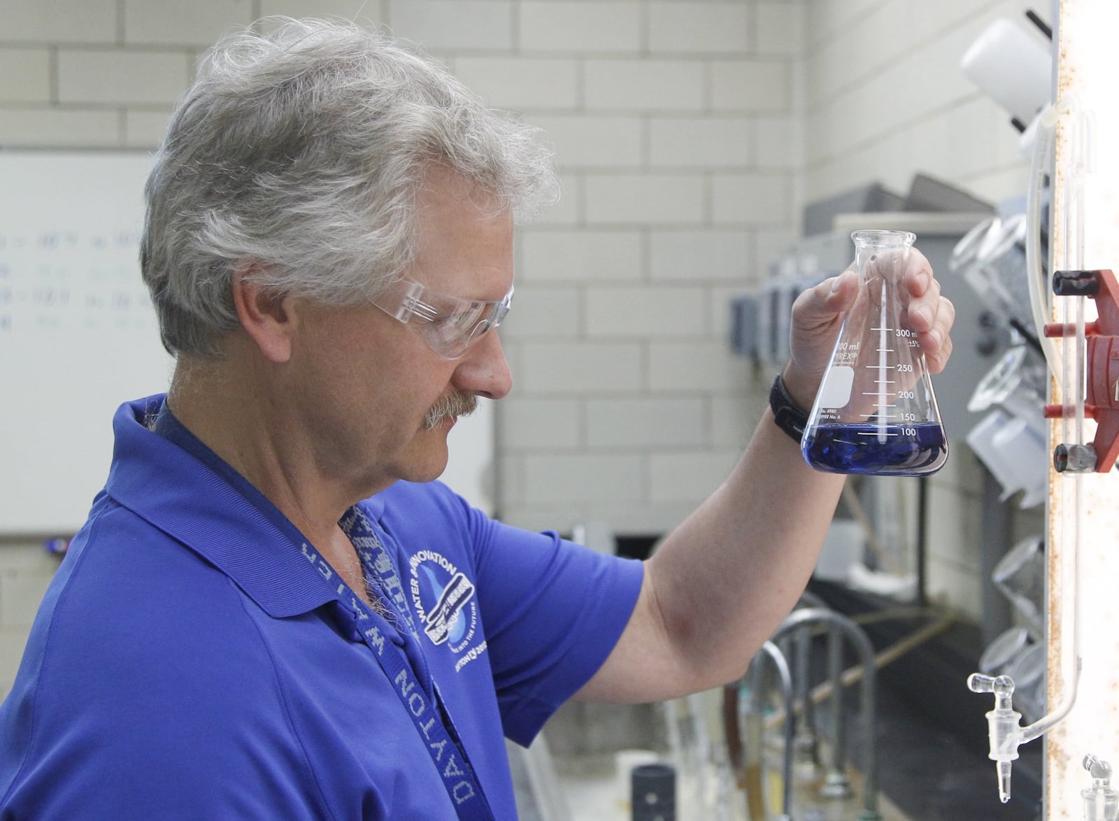 Tim Truman, a city of Dayton Department of Water research and control specialist, demonstrates how water is sampled for mineral content at the city’s Ottawa Water Treatment Plant. CHRIS STEWART / STAFF