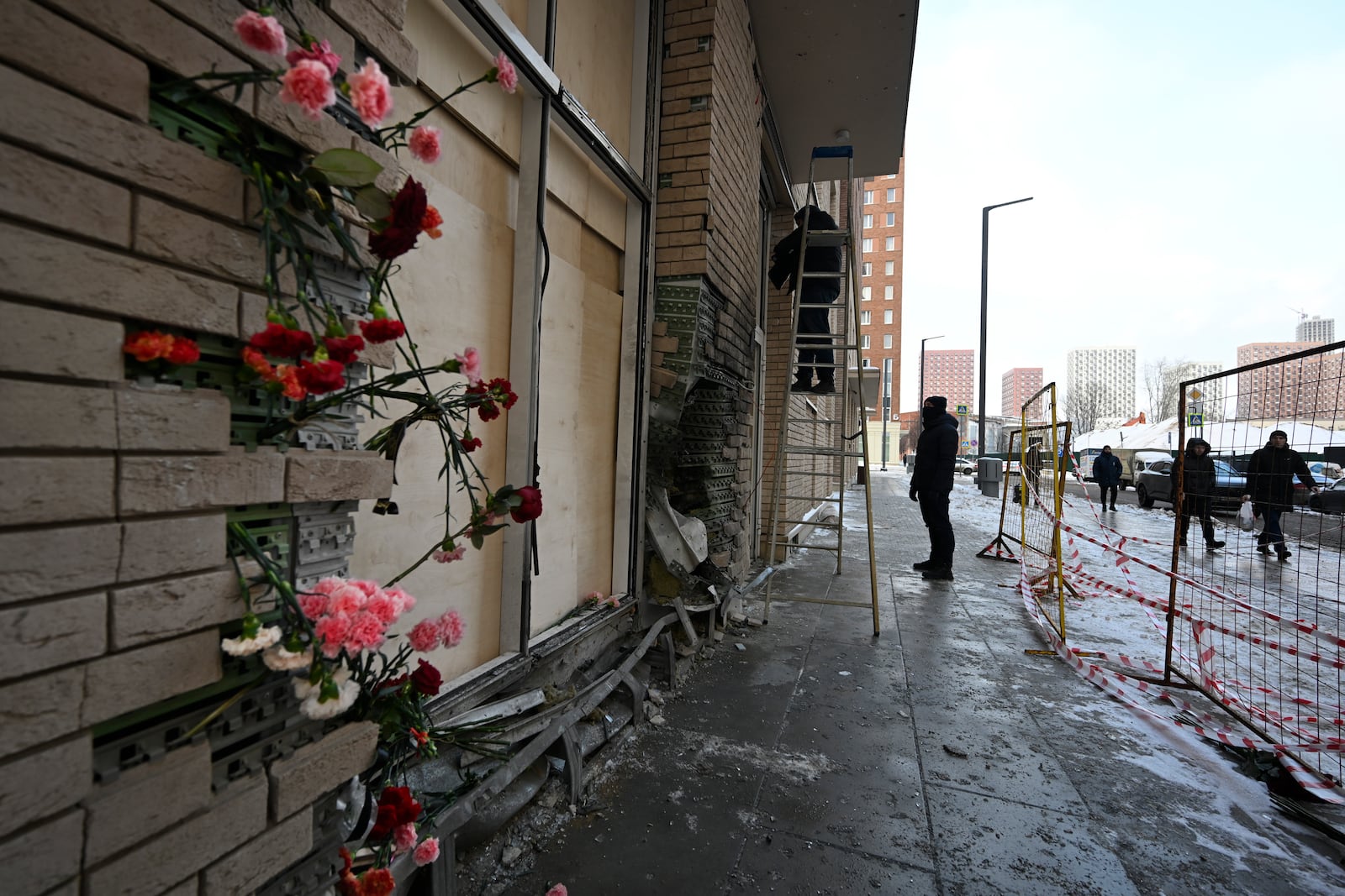 Flowers are attached to the fassade of a residential apartment's block in Moscow, Russia, Wednesday, Dec. 18, 2024, where Lt. General Igor Kirillov, the head of Russia's Nuclear, Biological, and Chemical Defence Forces and his assistant Ilya Polikarpov were killed by an explosive device. (AP Photo/Dmitry Serebryakov)