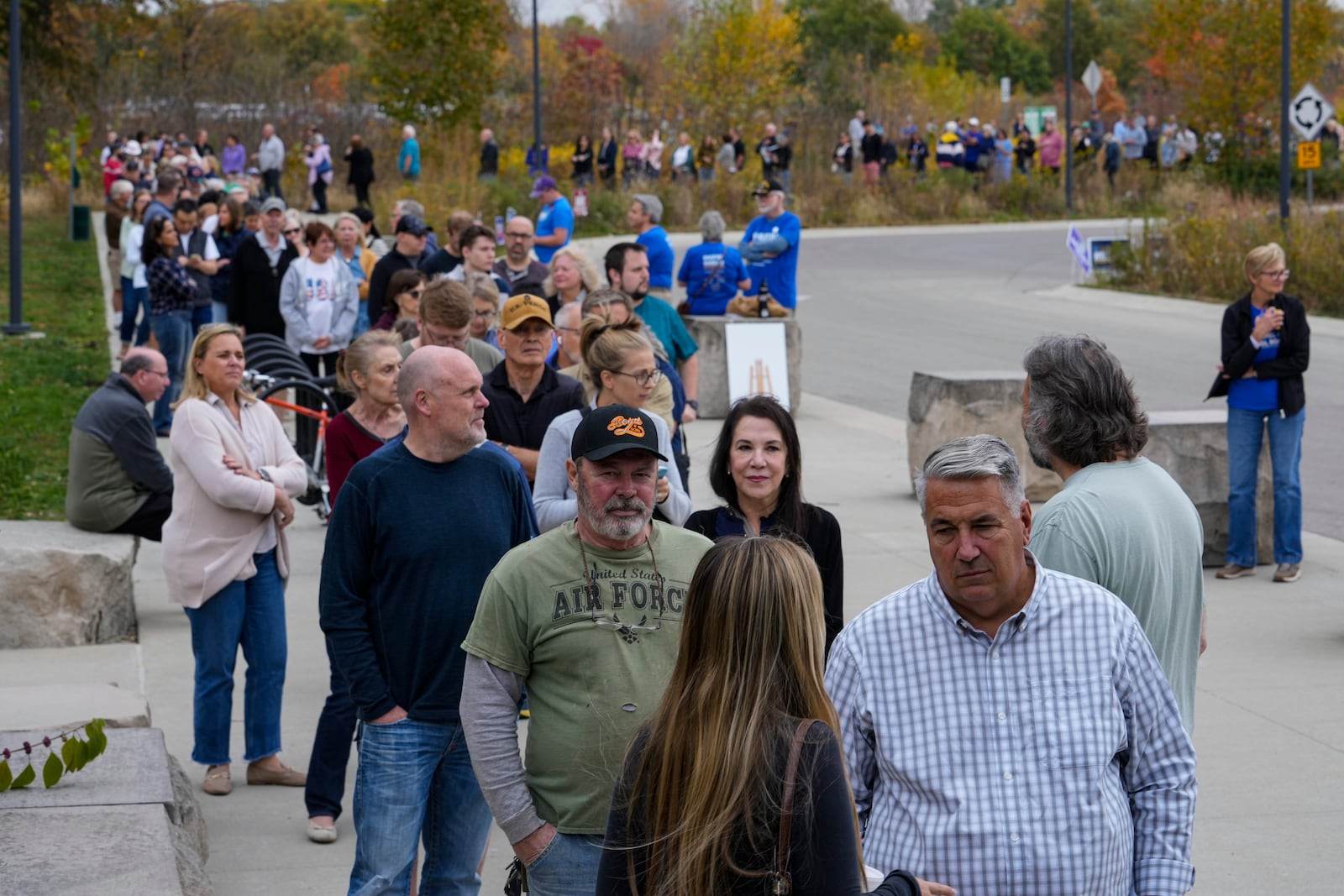 Voters line up to vote as a early voting location opened in Carmel, Ind., Wednesday, Oct. 23, 2024. (AP Photo/Michael Conroy)