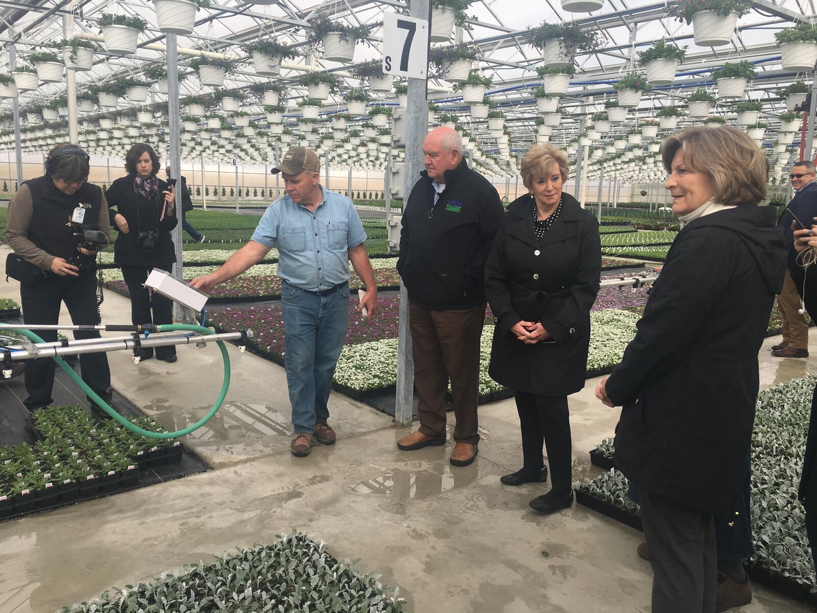 Sonny Perdue and SBA Administrator McMahon examine the sprinkler system at Amherst Greenhouse in Harrod on Wednesday morning.