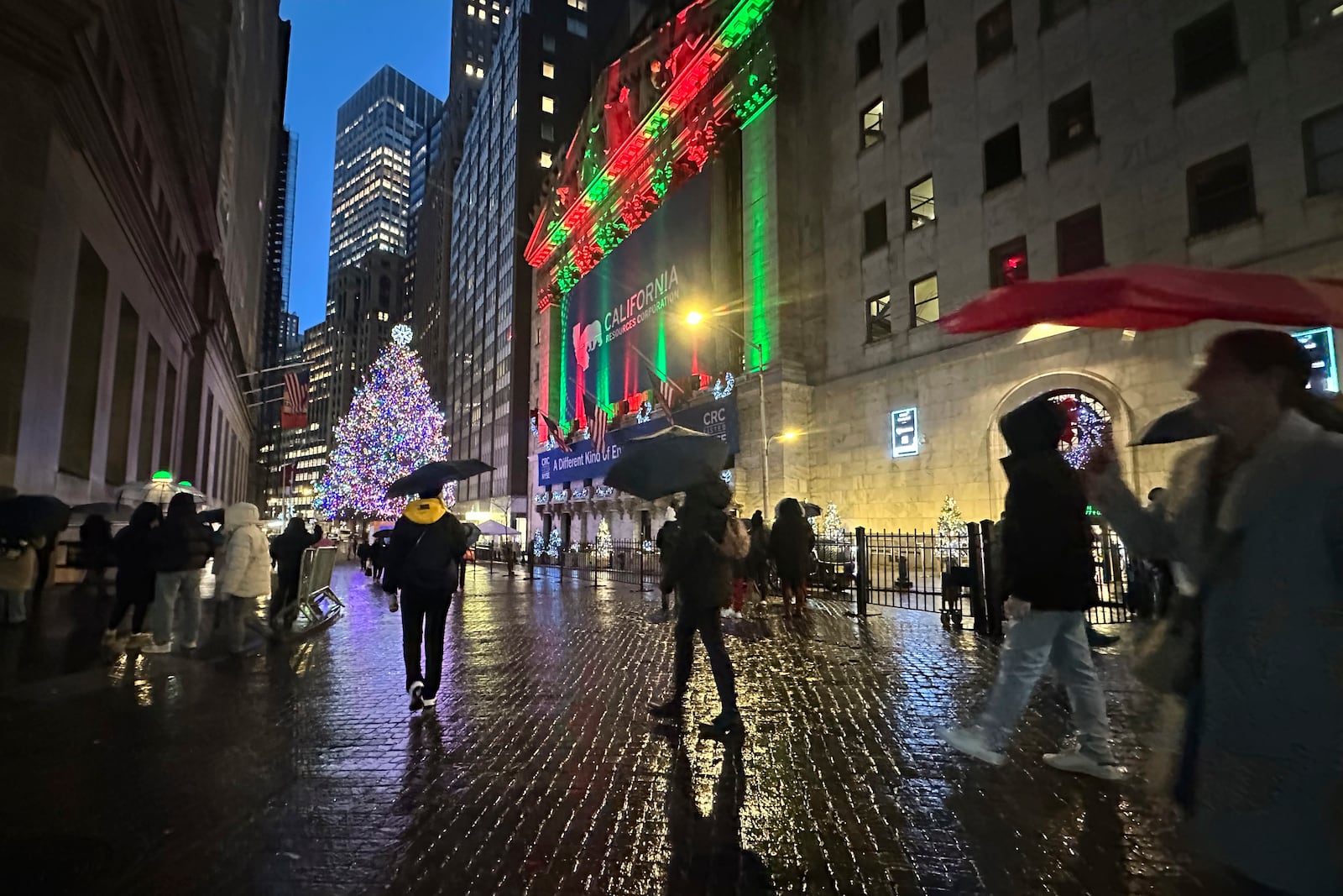 People pass the New York Stock Exchange in New York's Financial District on Wednesday Dec.11, 2024. (AP Photo/Peter Morgan)