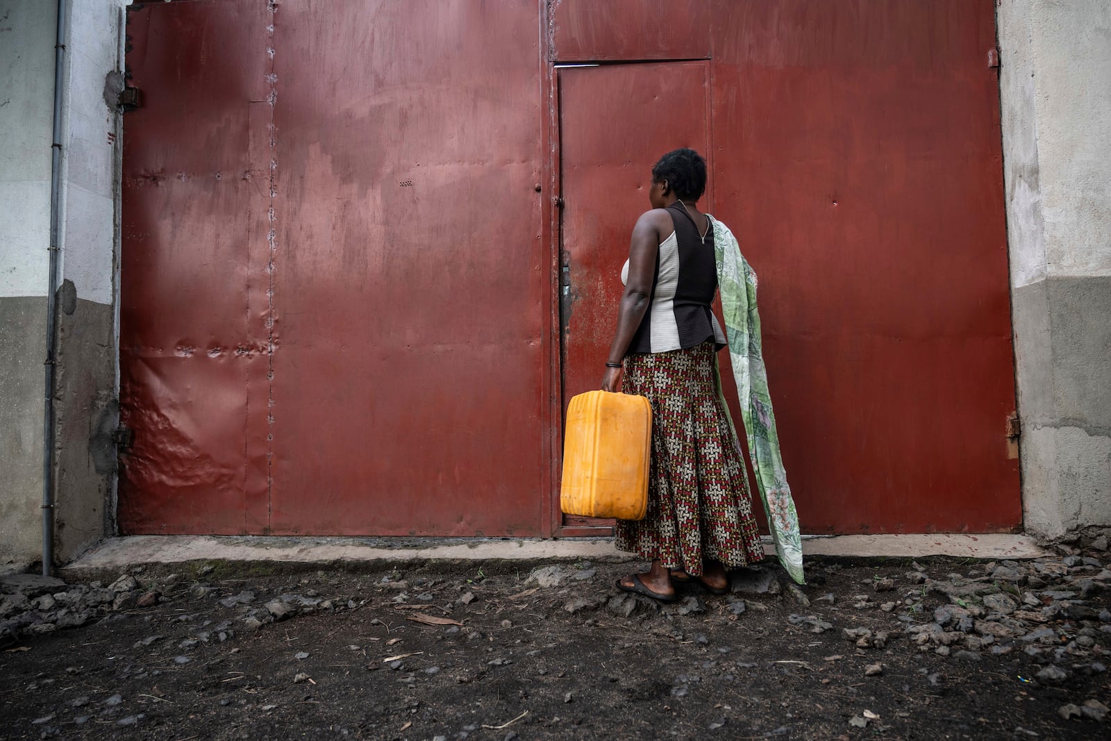 Zawadi Sifa, 35, mother of seven, who has been fleeing fighting from camp to camp, carries water in her latest displaced camp in Goma, Democratic Republic of the Congo, Thursday, Feb. 5, 2025.(AP Photo/Moses Sawasawa)